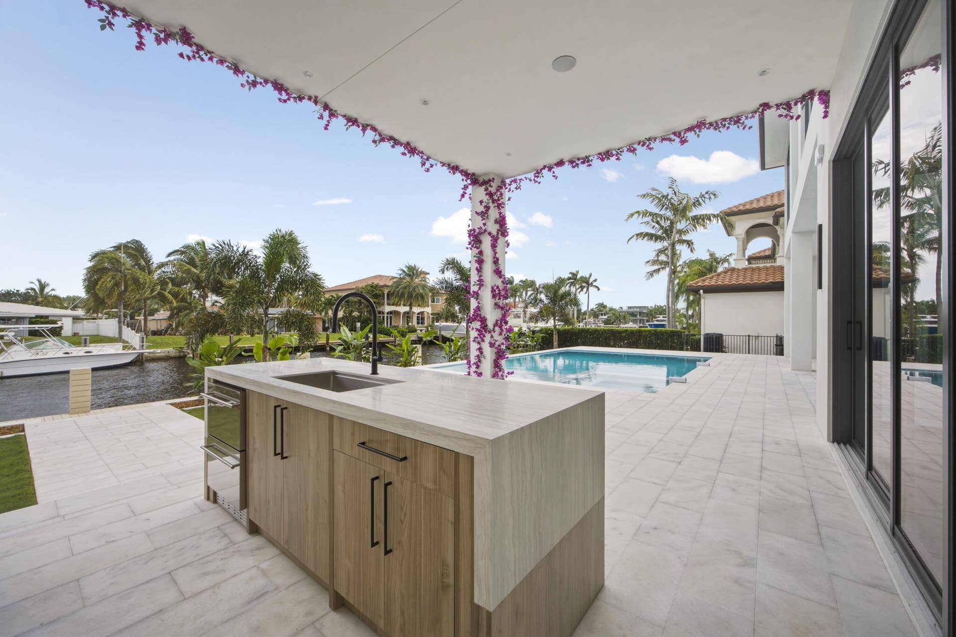 2921 NE 23RD Street, Pompano Beach, FL 33062 Outdoor cabinetry with Neolith Countertops and waterfall gas grill, fridge