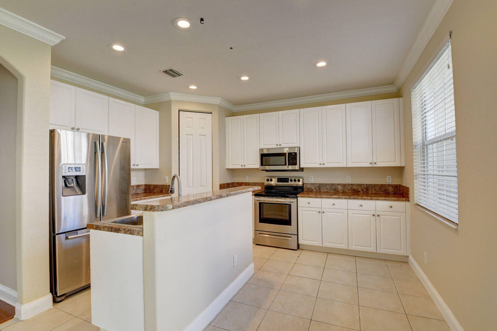 4353 Legacy Court, Delray Beach, FL 33445 Kitchen with white cabinetry, stainless steel appliances and a center island.
