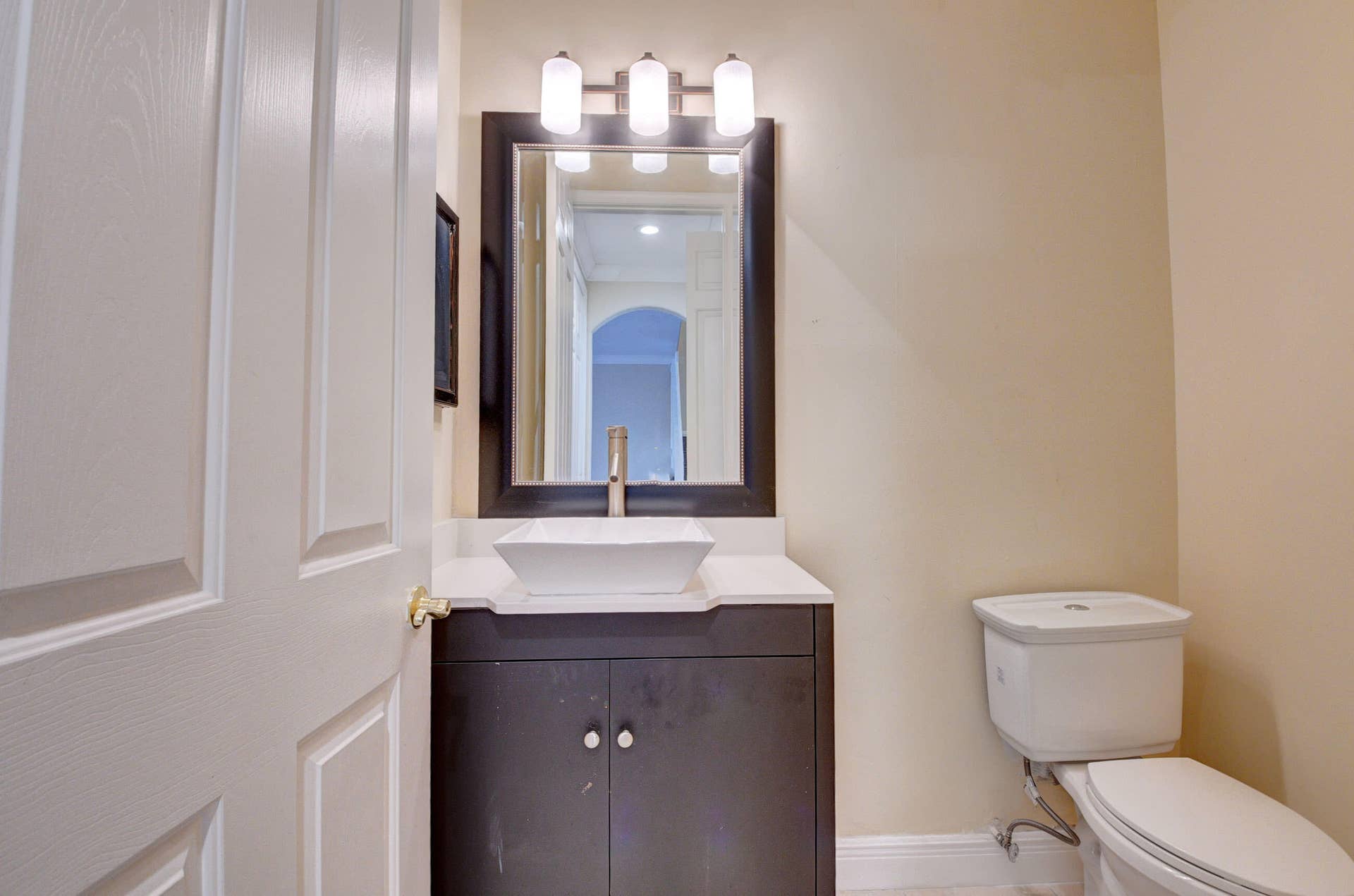 4353 Legacy Court, Delray Beach, FL 33445 Half bath with dark vanity and framed mirror.