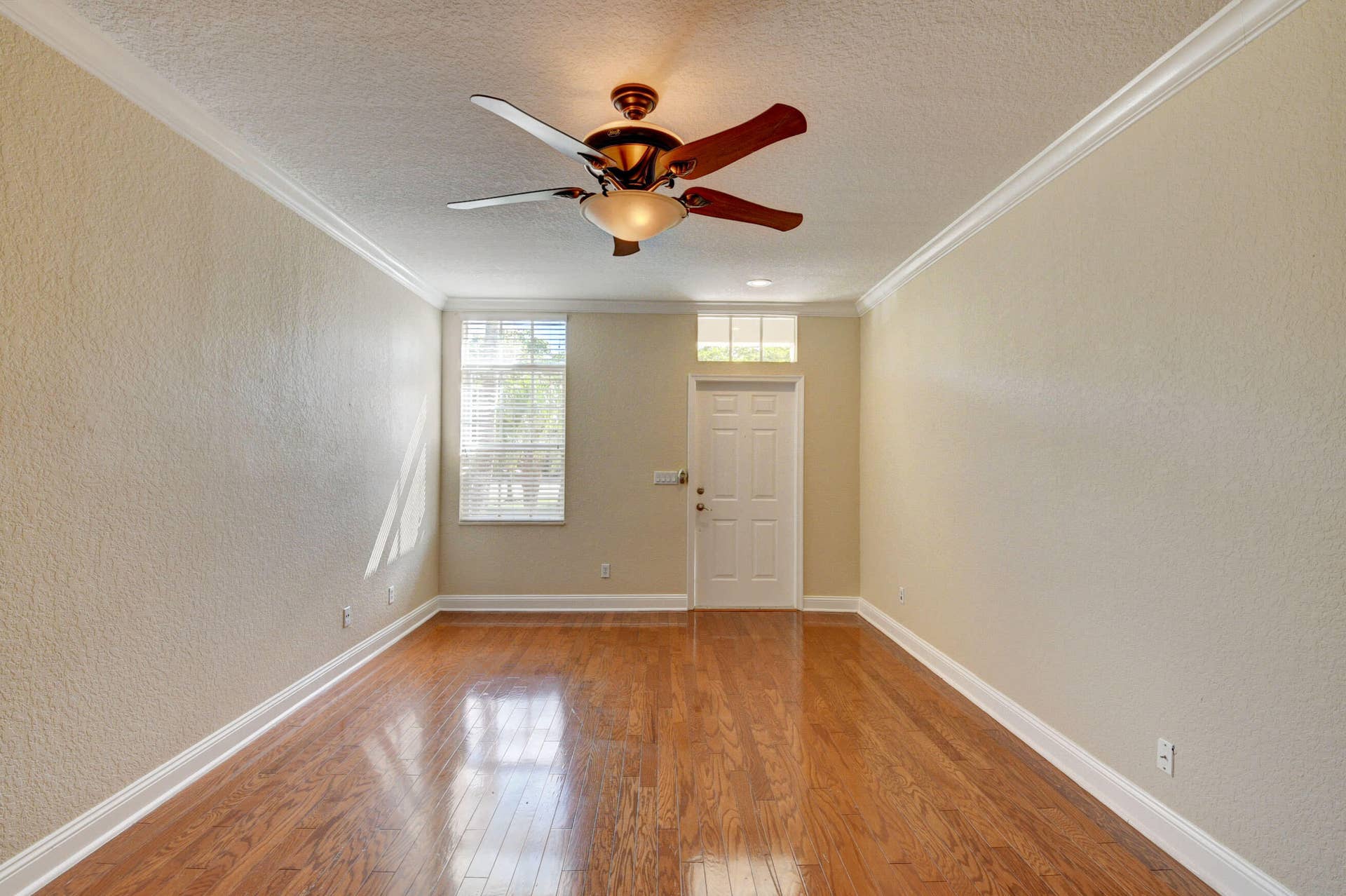 4353 Legacy Court, Delray Beach, FL 33445 Living area with ceiling fan and windows near the front entry.