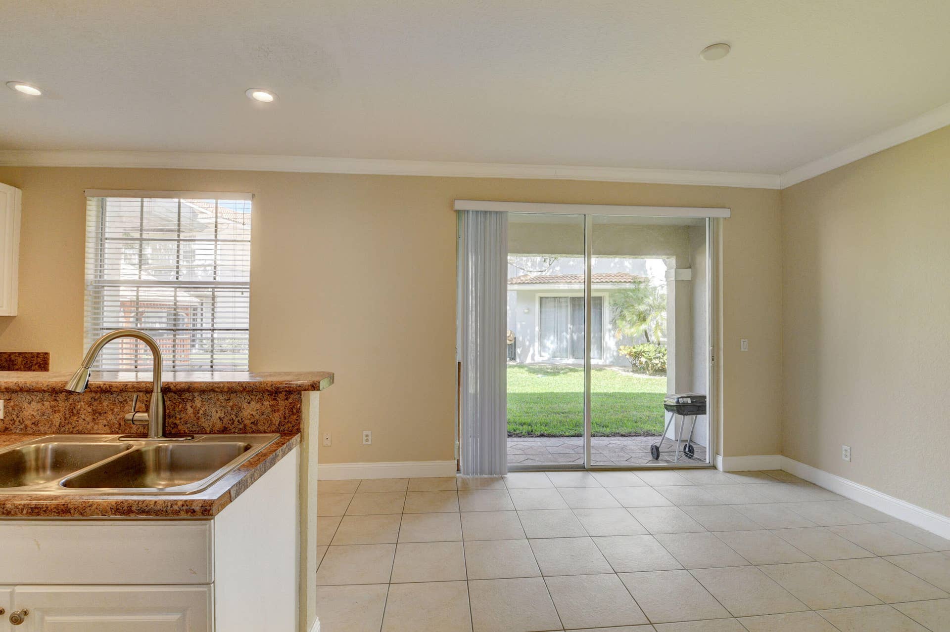 4353 Legacy Court, Delray Beach, FL 33445 Kitchen sink with window and sliding glass doors leading outside.