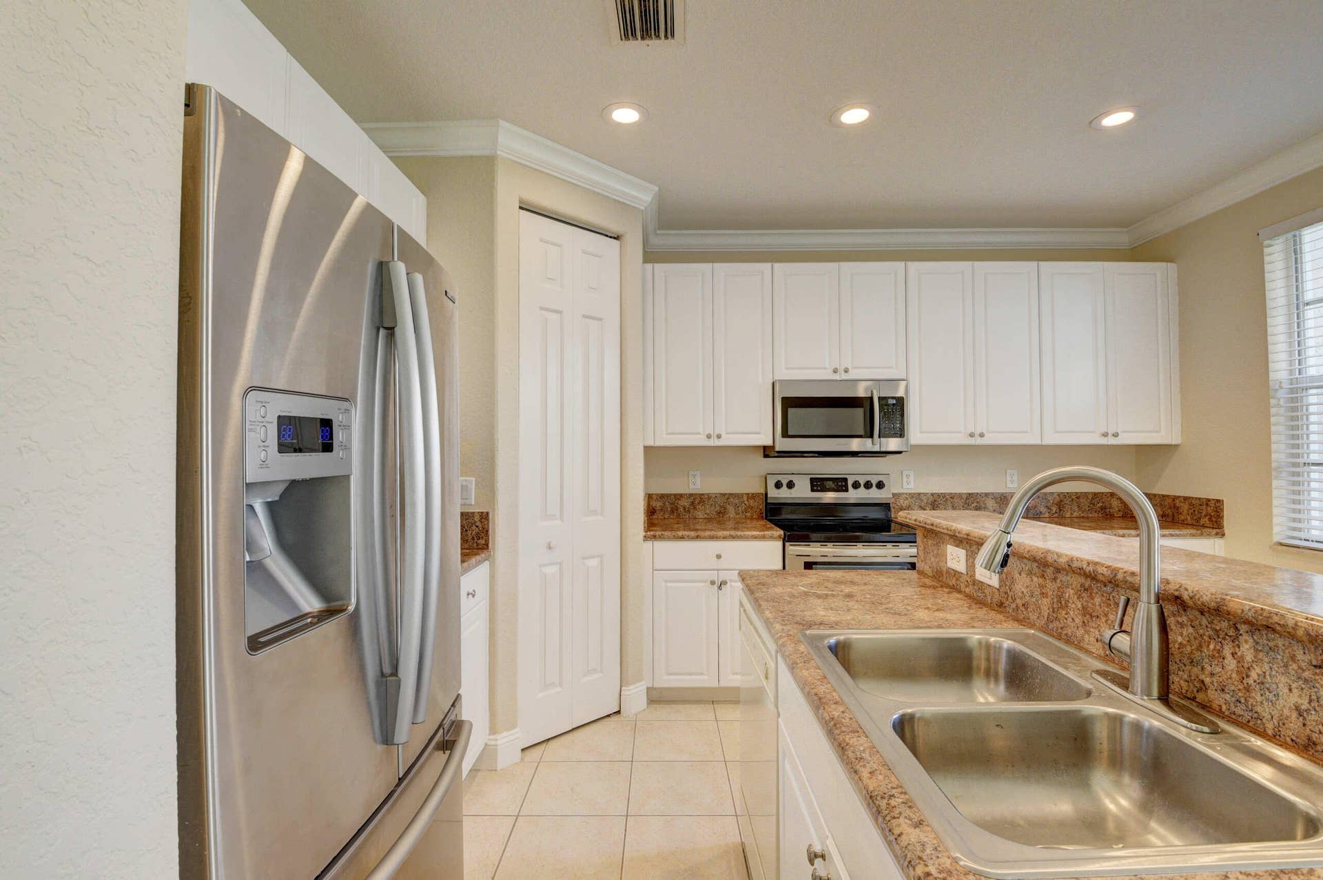 4353 Legacy Court, Delray Beach, FL 33445 Kitchen with stainless steel refrigerator, double sink and generous counter space.