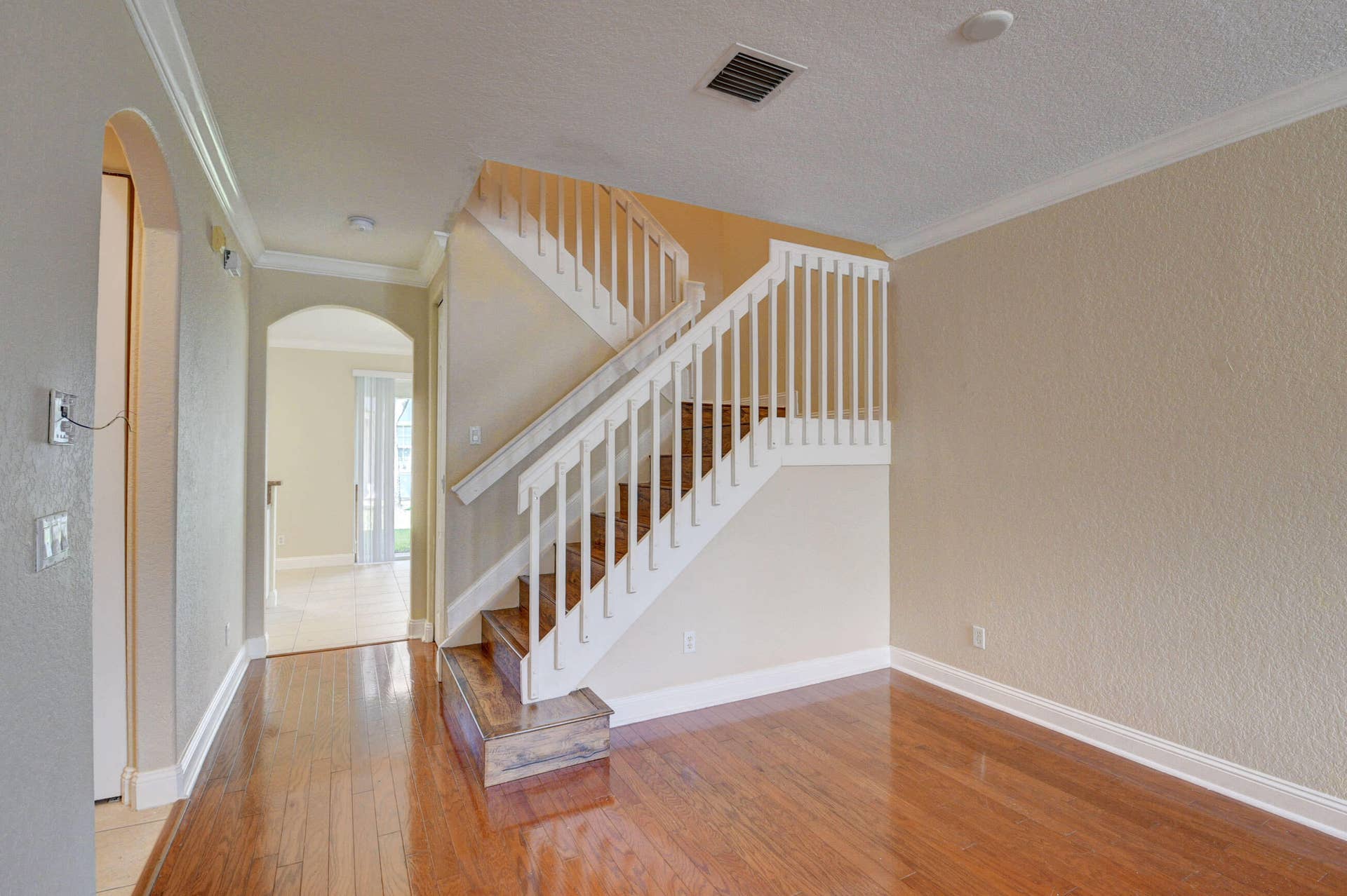 4353 Legacy Court, Delray Beach, FL 33445 Staircase with white railing and wood-look flooring on the main level.