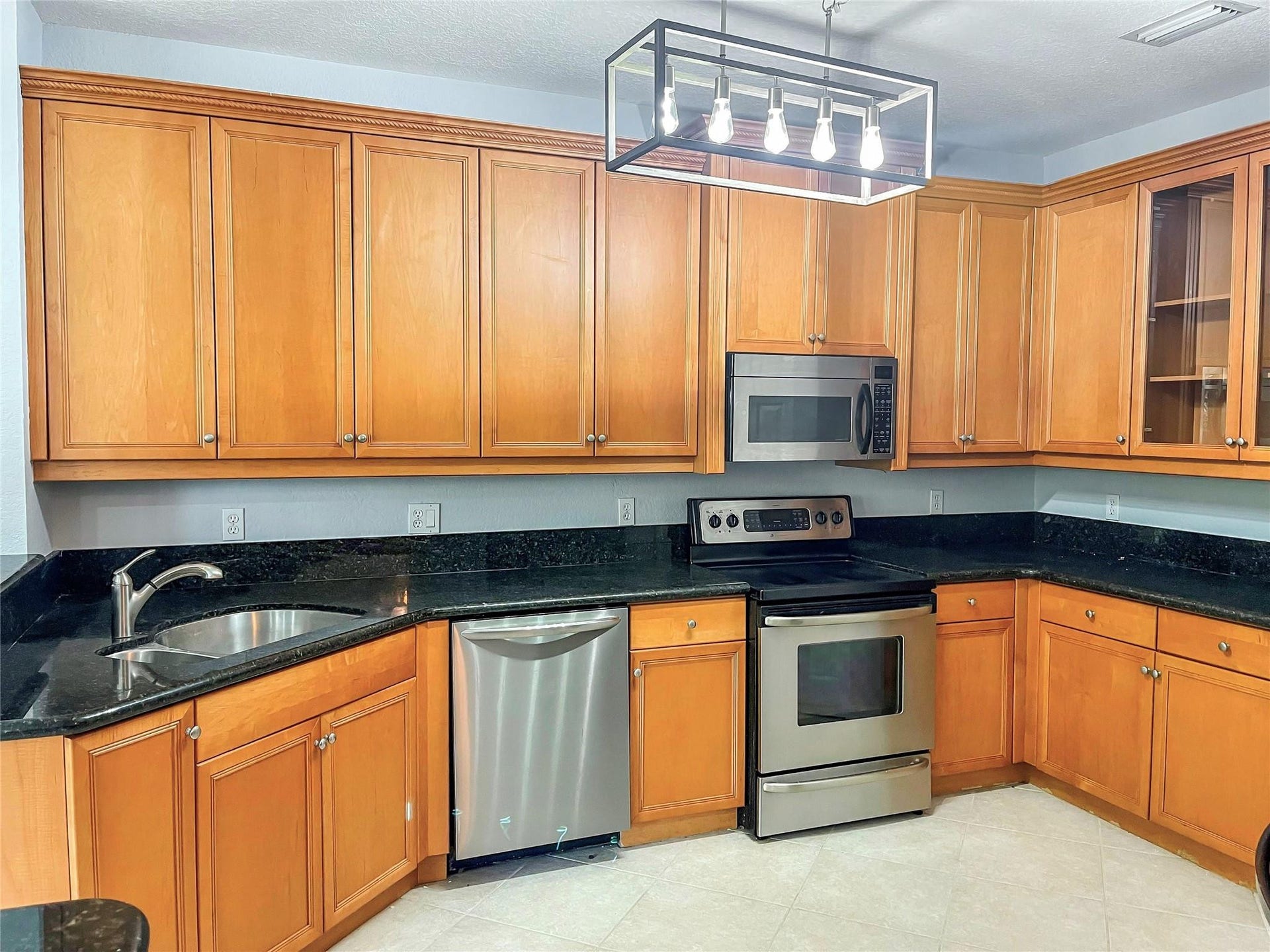 5780 NW 120TH Avenue, Coral Springs, Coral Springs, FL 33076 Kitchen featuring wood cabinetry, stone countertops, stainless steel appliances, and a linear open-frame pendant light fixture
