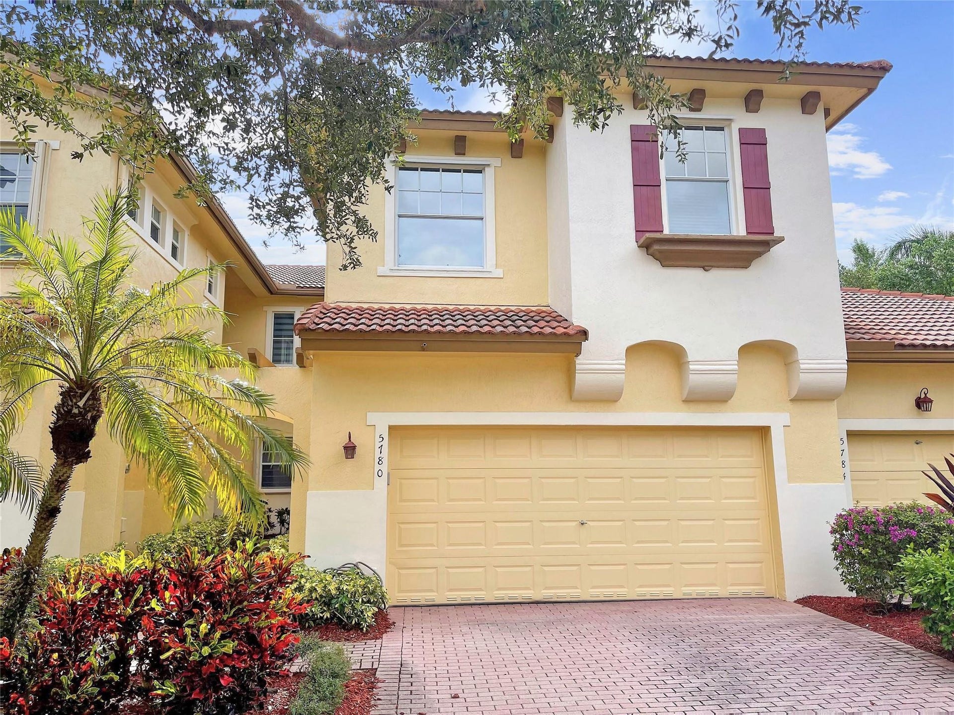 5780 NW 120TH Avenue, Coral Springs, Coral Springs, FL 33076 Stucco exterior featuring decorative corbels, a paver driveway, tiled roof accents, and window shutters