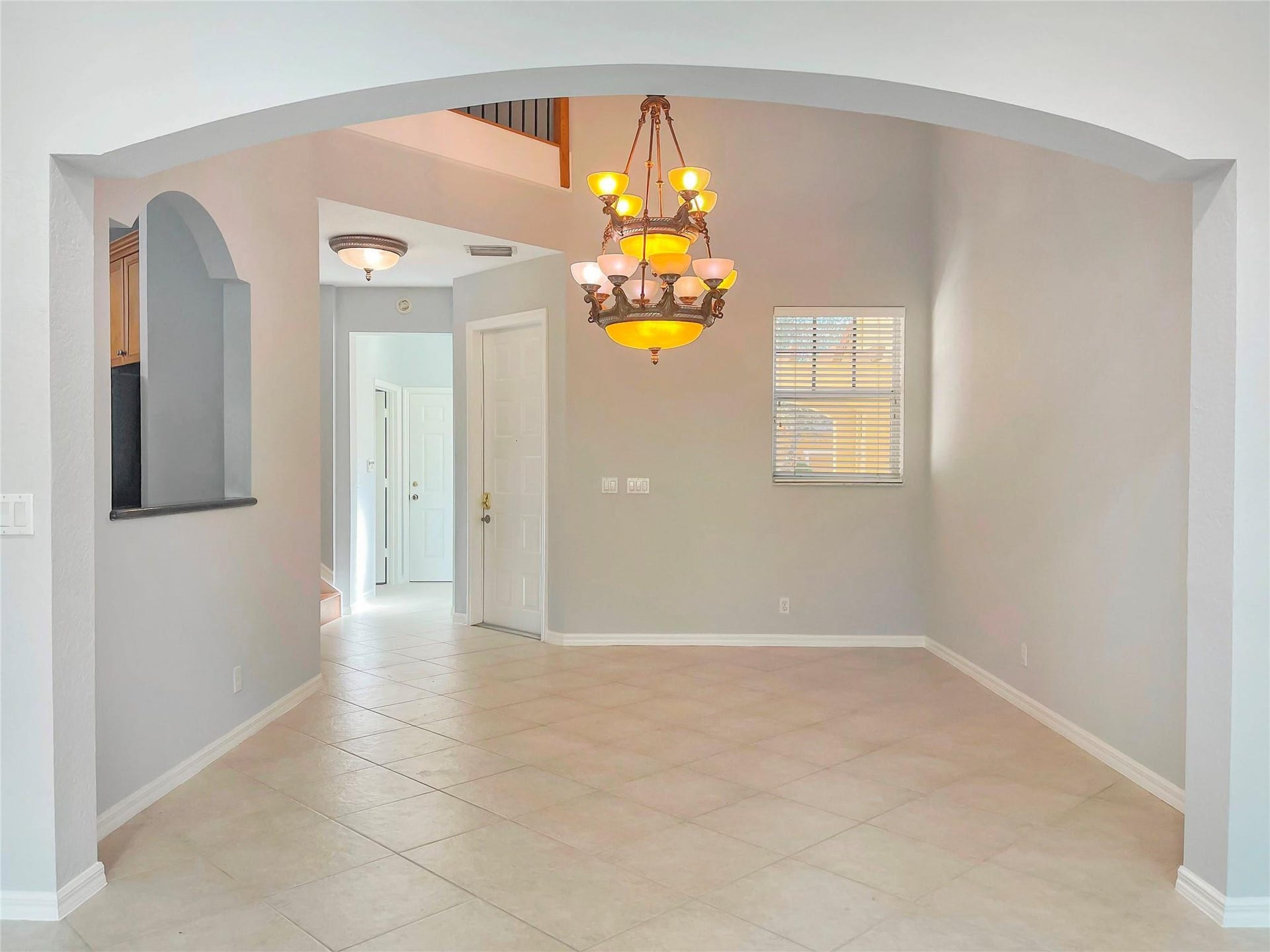 5780 NW 120TH Avenue, Coral Springs, Coral Springs, FL 33076 Arched entryway featuring tile flooring, a multi-tiered chandelier, a decorative wall niche, and vaulted ceilings