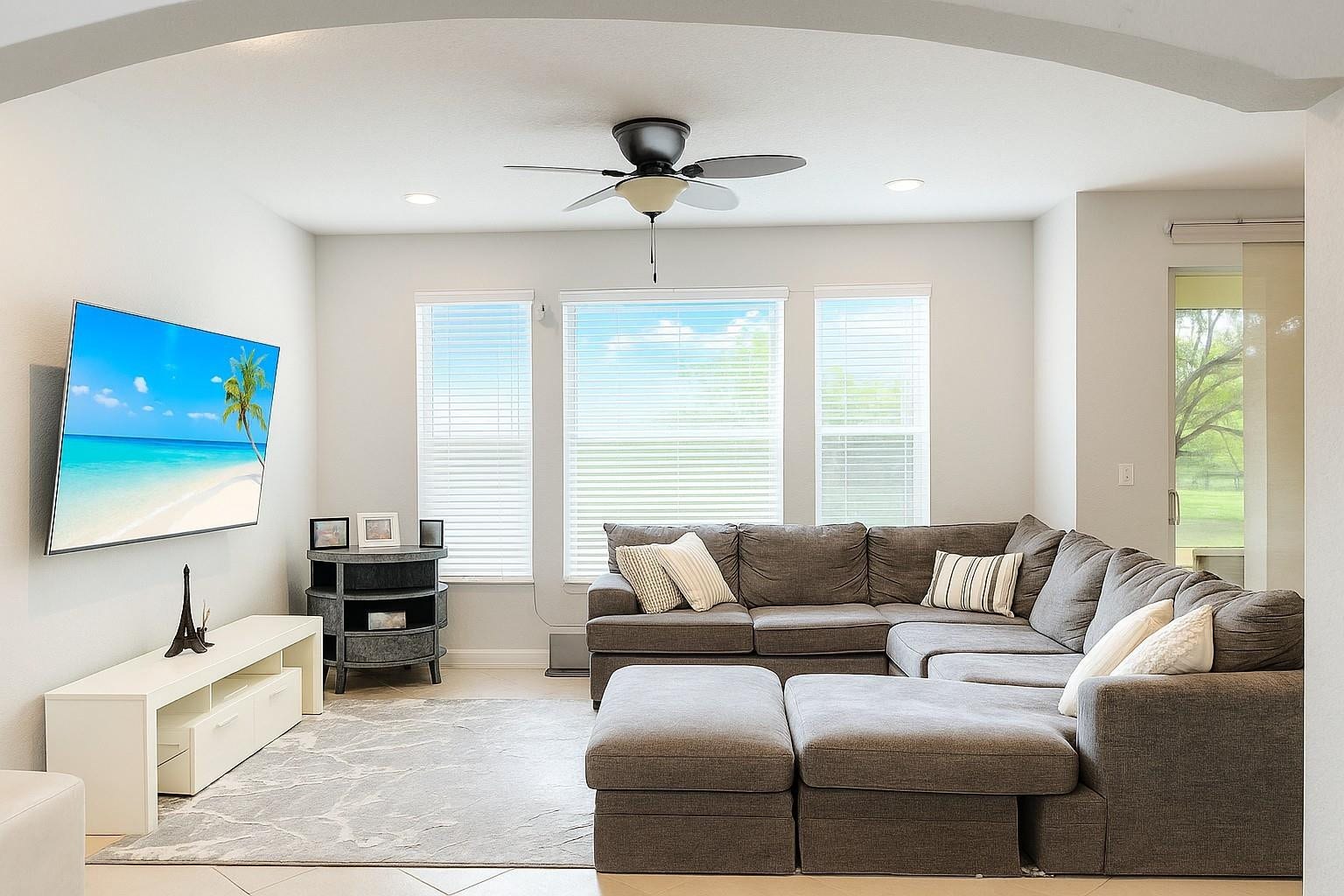5780 NW 120TH Avenue, Coral Springs, Coral Springs, FL 33076 Open-concept room featuring a prominent arched entry, triple window configuration with blinds, ceiling fan, and ceramic tile flooring
