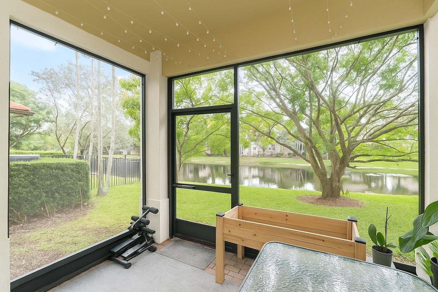 5780 NW 120TH Avenue, Coral Springs, Coral Springs, FL 33076 Screened-in patio featuring floor-to-ceiling window panels, black metal framing, a dedicated screen door, concrete flooring, and water frontage