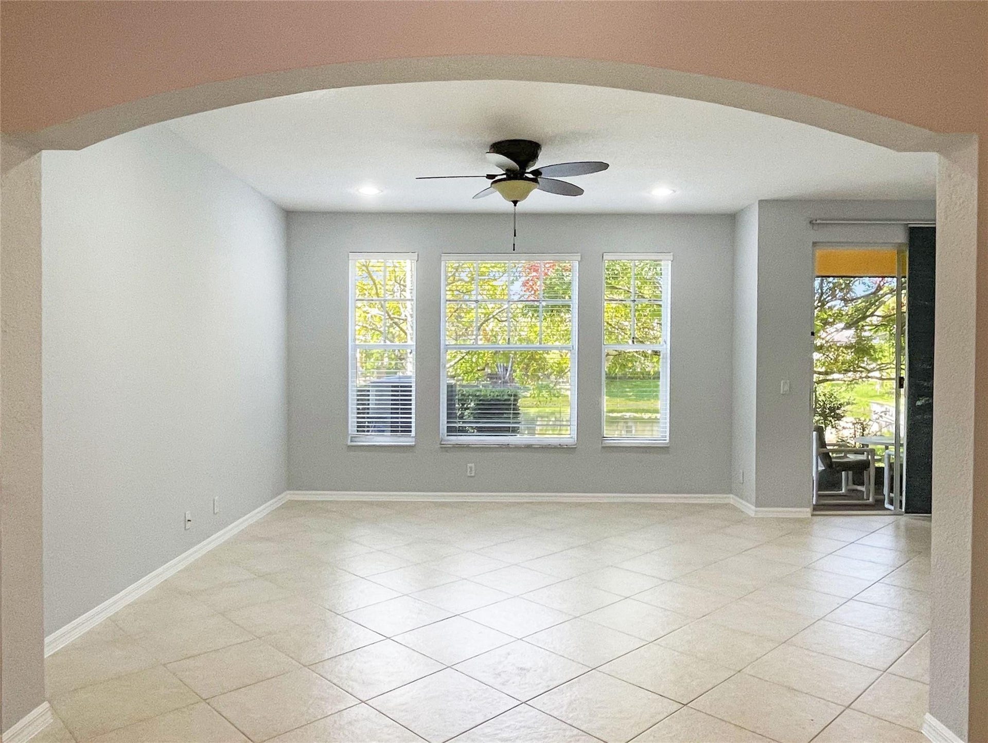5780 NW 120TH Avenue, Coral Springs, Coral Springs, FL 33076 Arched entryway featuring neutral-toned tile flooring, recessed ceiling lighting, a multi-blade ceiling fan, and large windows with grid detailing