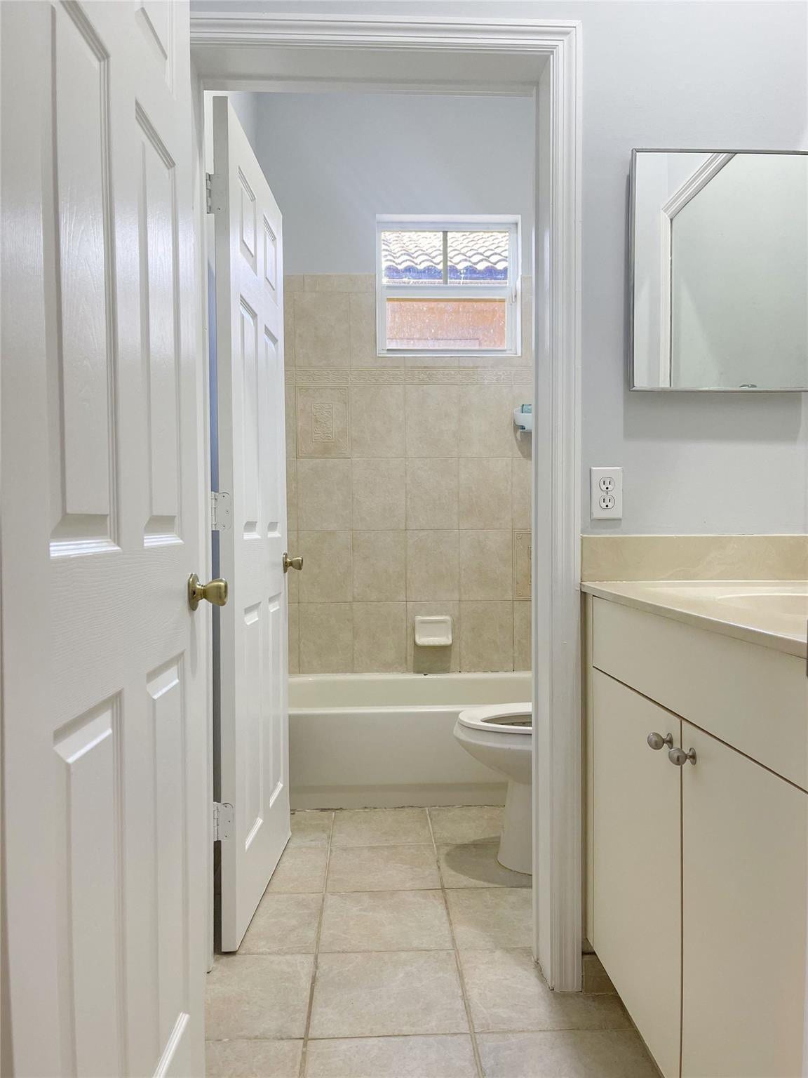 5780 NW 120TH Avenue, Coral Springs, Coral Springs, FL 33076 Bathroom featuring a vanity with a neutral-toned countertop, ceramic tile flooring, a tub-shower combination with ceramic wall tile, and a rectangular mirror