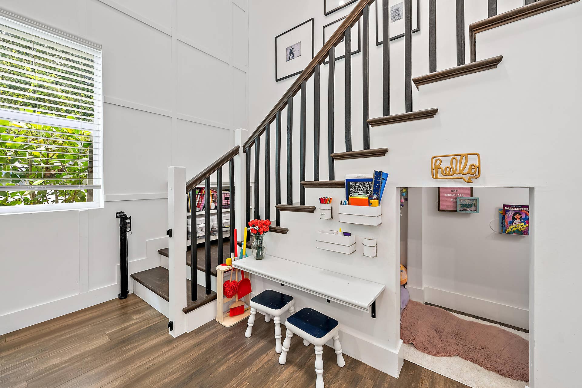 6204 SAND PINE Court, Jupiter, Jupiter, FL 33458 Wood-finish flooring, staircase with dark treads and white risers, white wainscoting, built-in under-stair desk, and a window with blinds