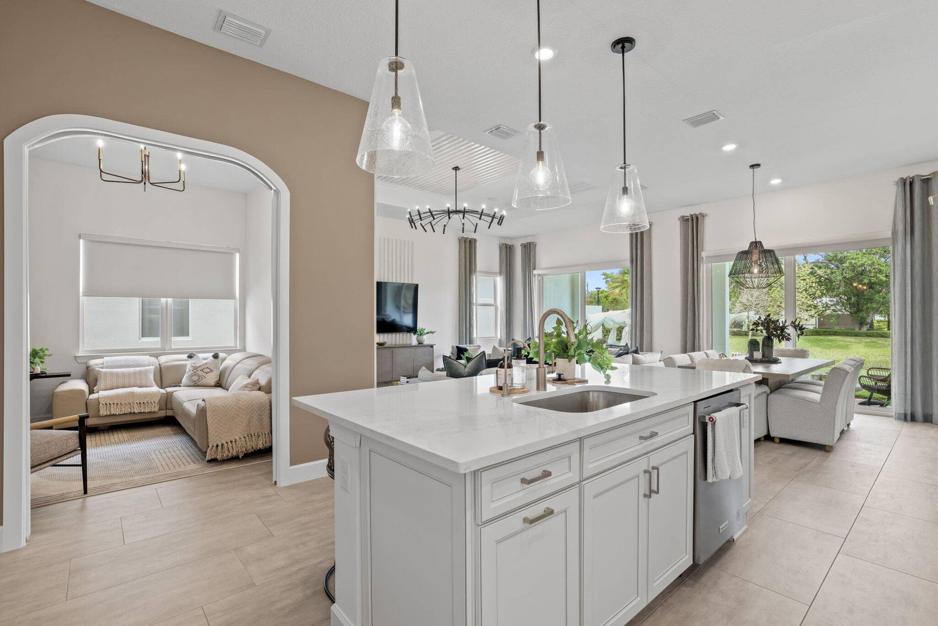 205 GEILLIS Path, Delray Beach, FL 33445 Kitchen featuring a center island with quartz countertops, custom shaker-style cabinetry, stainless steel sink, and glass pendant lighting, complemented by tile flooring