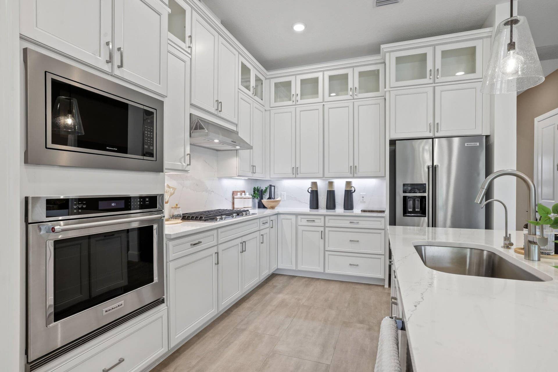 205 GEILLIS Path, Delray Beach, FL 33445 Kitchen featuring white shaker-style cabinetry with glass-front uppers, stainless steel appliances, stone countertops, and wood-finish flooring