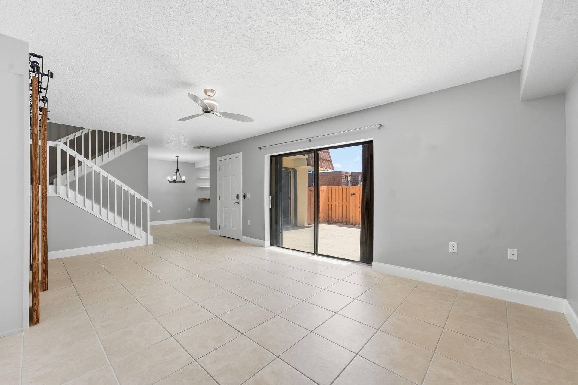 236 CHARTER Way, West Palm Beach, FL 33407 Tiled flooring, white staircase with railing, sliding glass door, ceiling fan, and built-in shelving