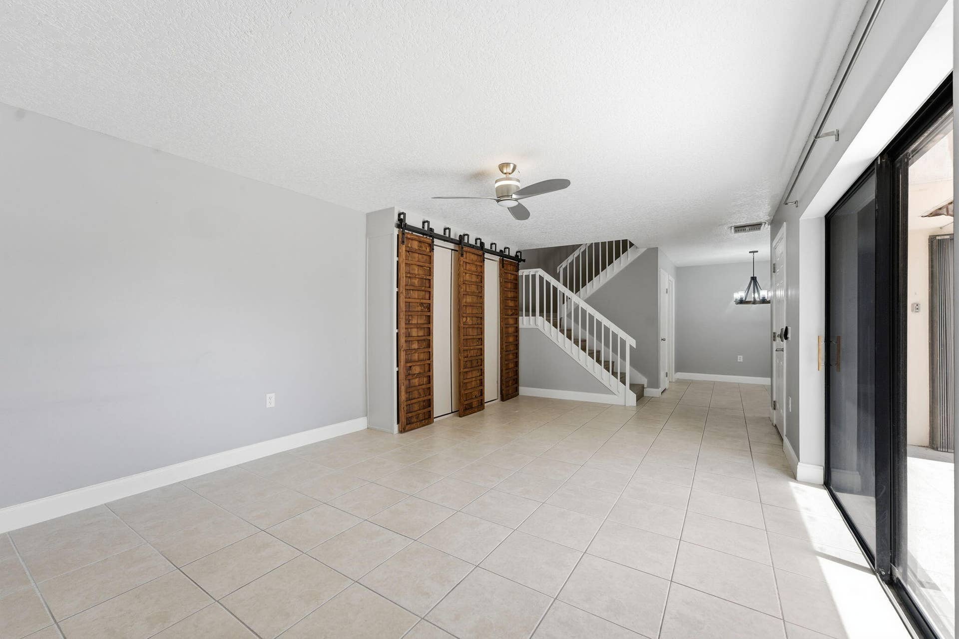 236 CHARTER Way, West Palm Beach, FL 33407 Spacious interior featuring tile flooring, a contemporary ceiling fan, and wood-panel barn doors