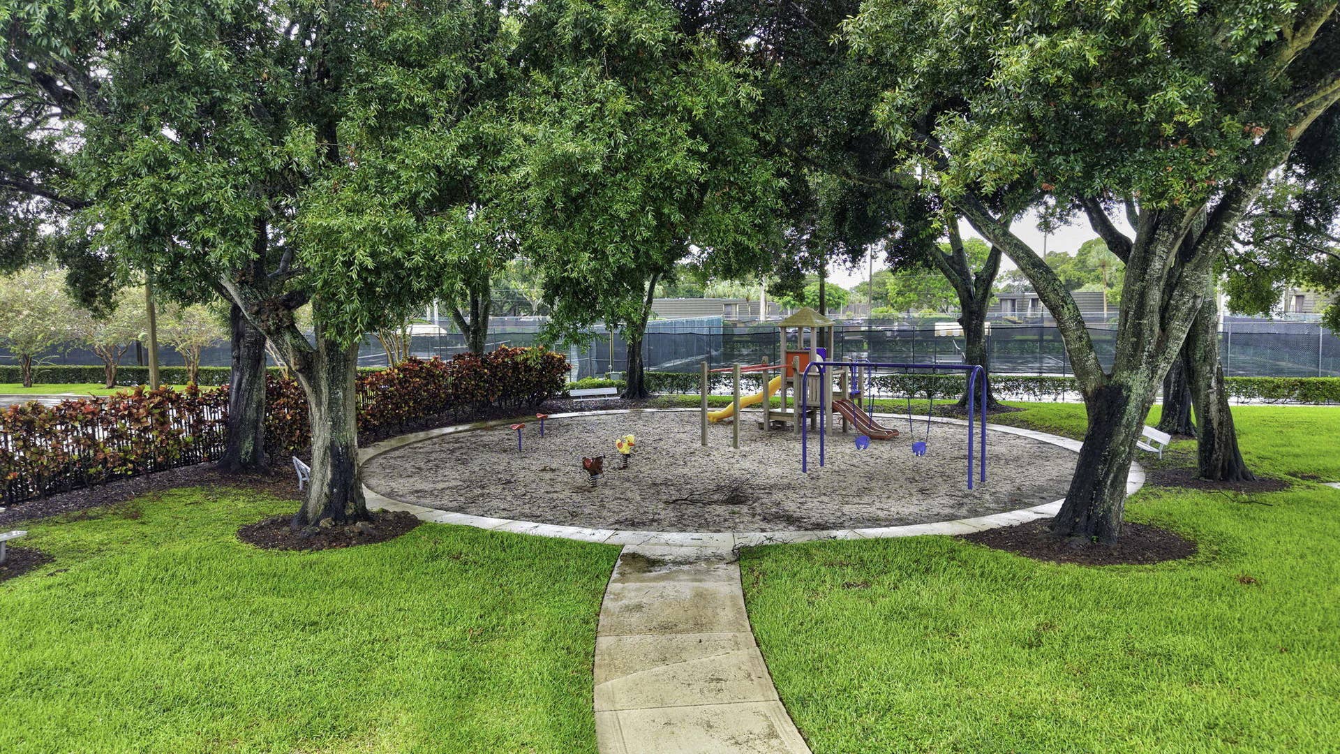 236 CHARTER Way, West Palm Beach, FL 33407 Central recreational area featuring a sand-based play space, swings, and slides