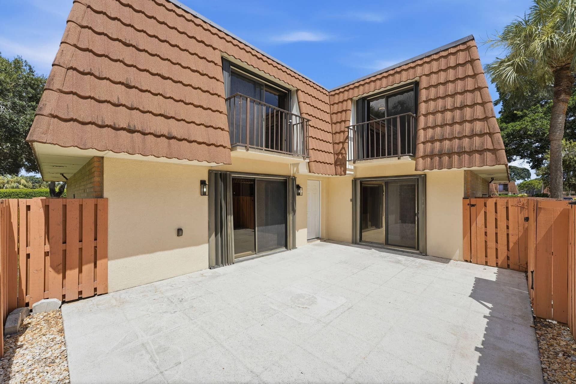 236 CHARTER Way, West Palm Beach, FL 33407 Private patio area with concrete pavers, dual sliding glass doors, and privacy fencing