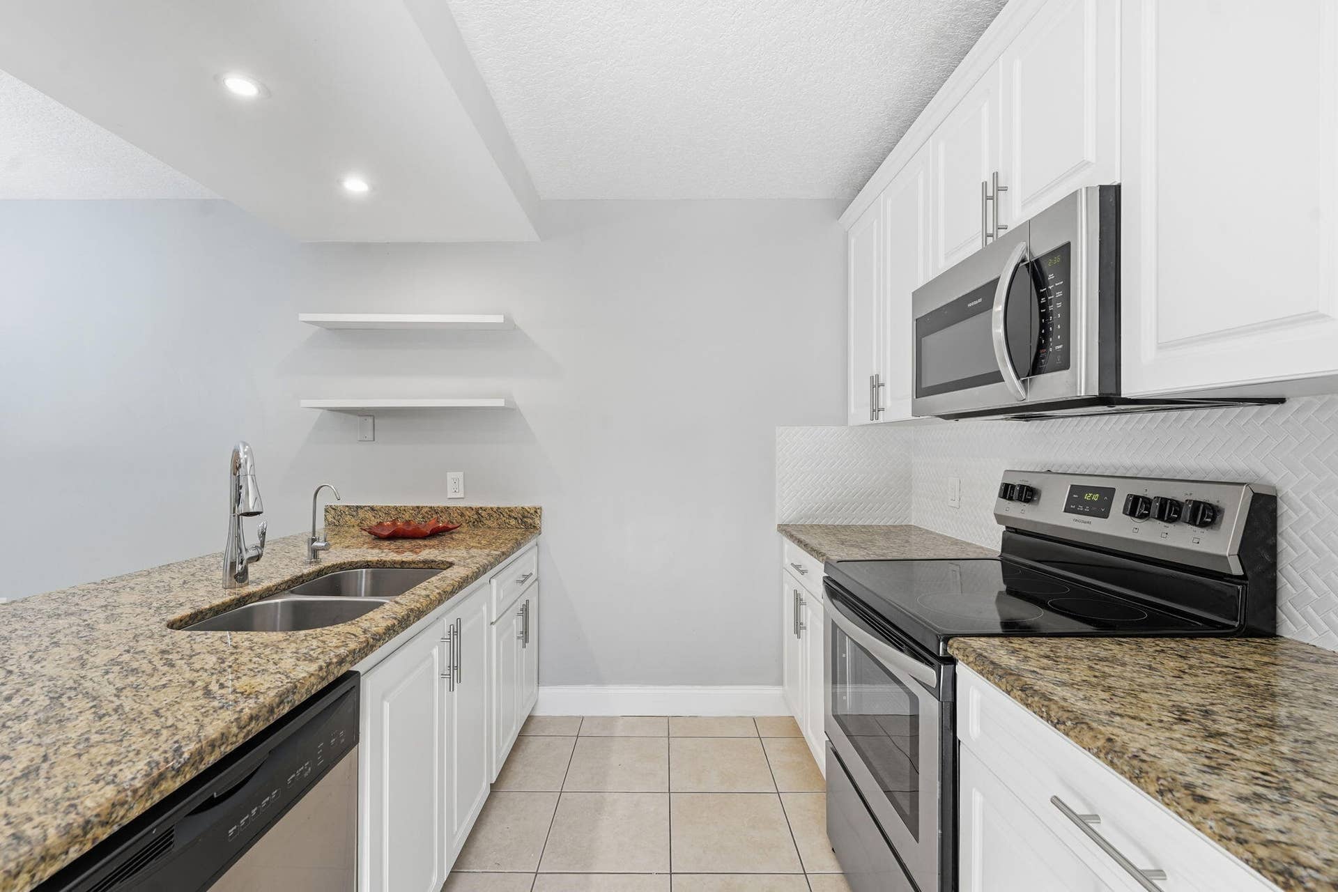 236 CHARTER Way, West Palm Beach, FL 33407 Kitchen featuring granite countertops, white cabinetry, stainless steel appliances, tile flooring, and recessed lighting