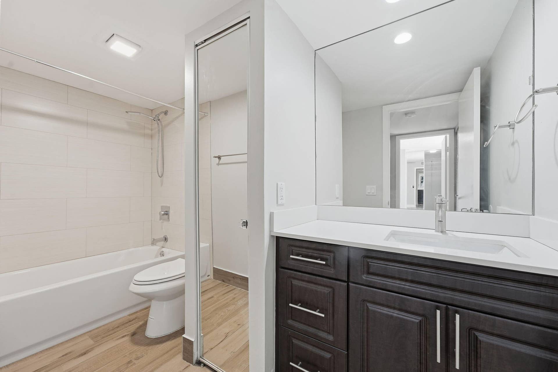 236 CHARTER Way, West Palm Beach, FL 33407 Bathroom with a dark wood-finish vanity, white countertop, integrated sink, and large wall-mounted mirror