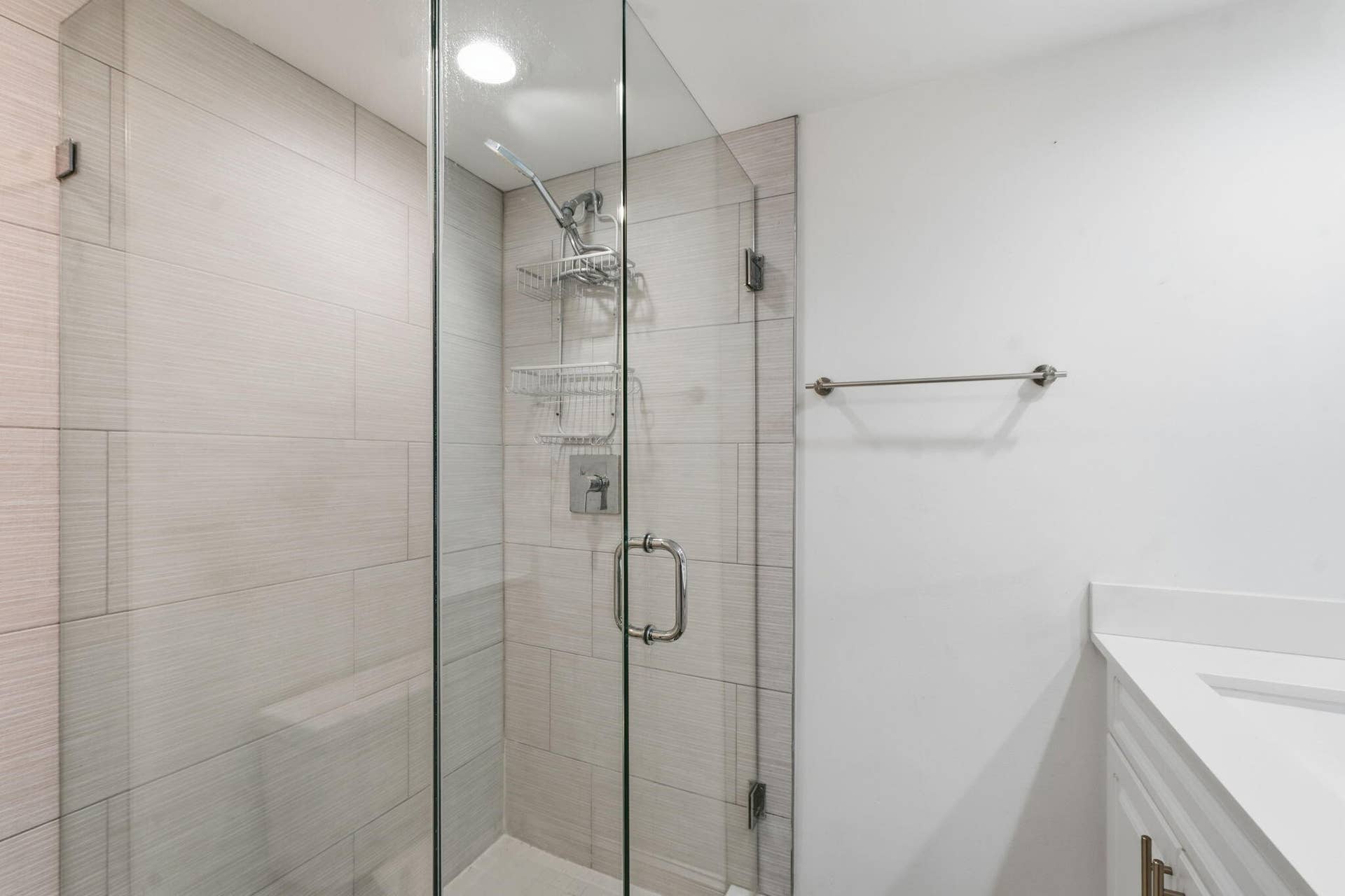 236 CHARTER Way, West Palm Beach, FL 33407 Glass-enclosed shower with subway tile surround, recessed lighting, and a chrome shower fixture