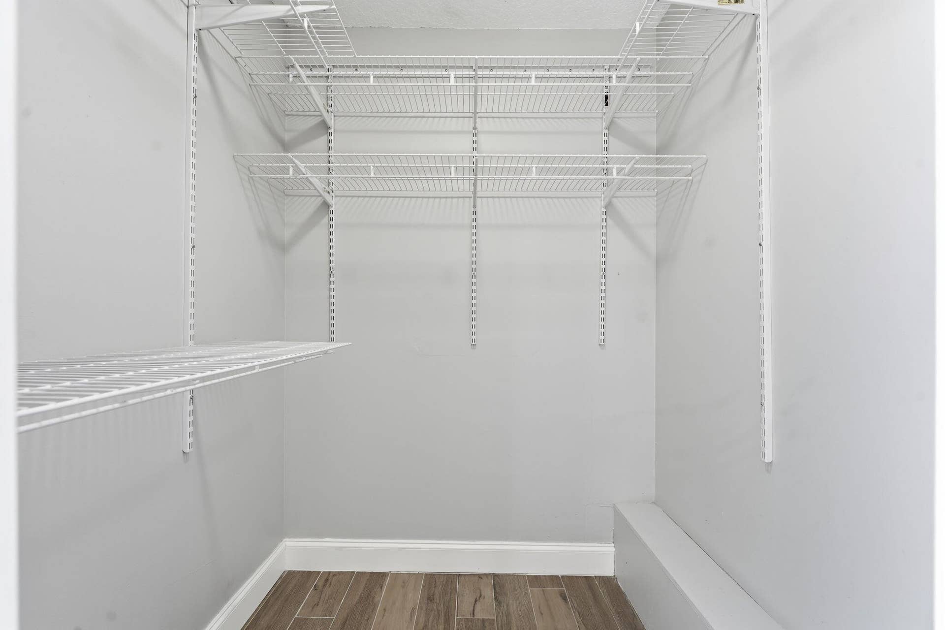 236 CHARTER Way, West Palm Beach, FL 33407 White wire shelving system, light gray wall paint, wood-finish flooring, and white trim