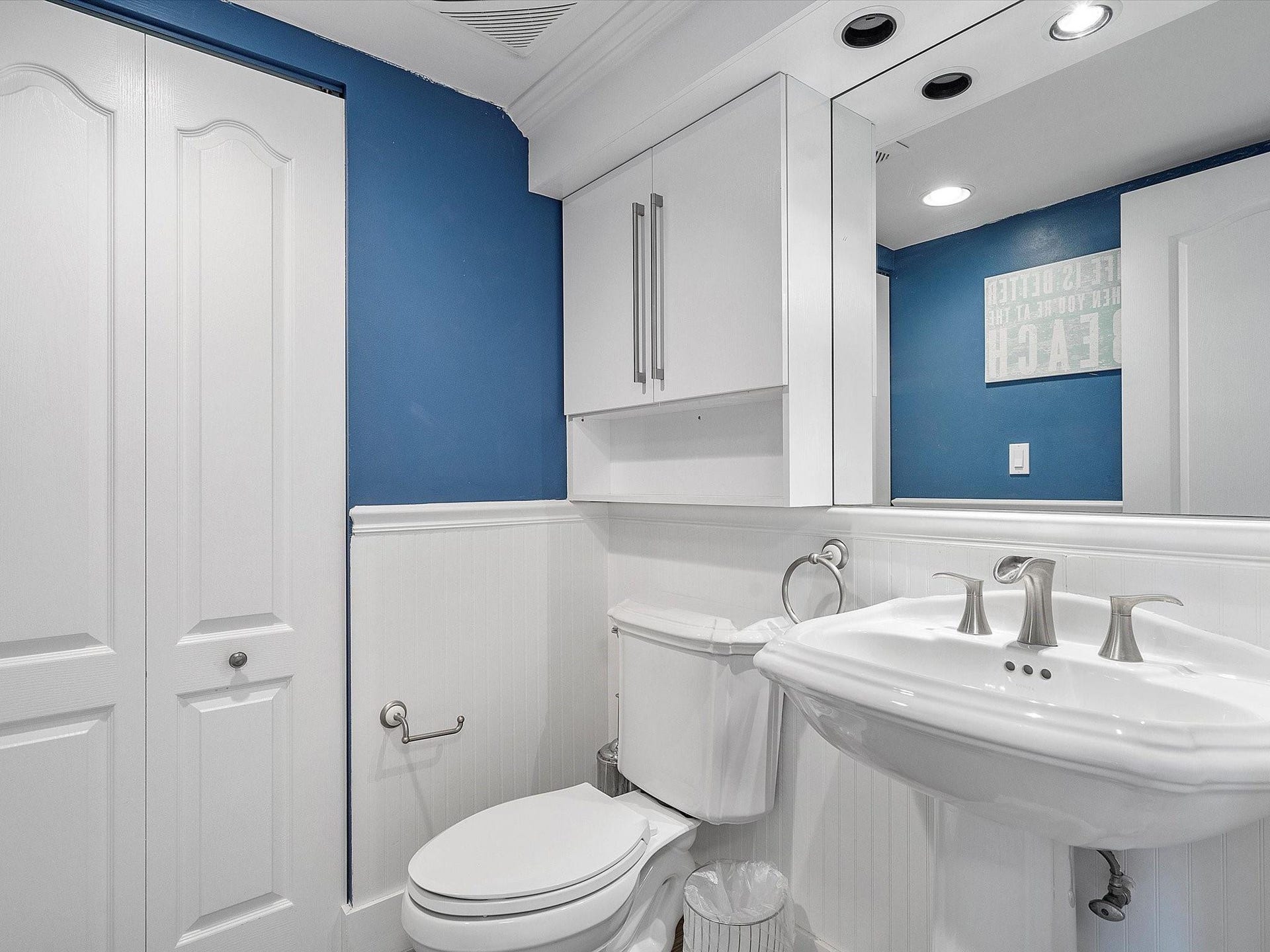 Guest bathroom with enclosed washer & dryer.
