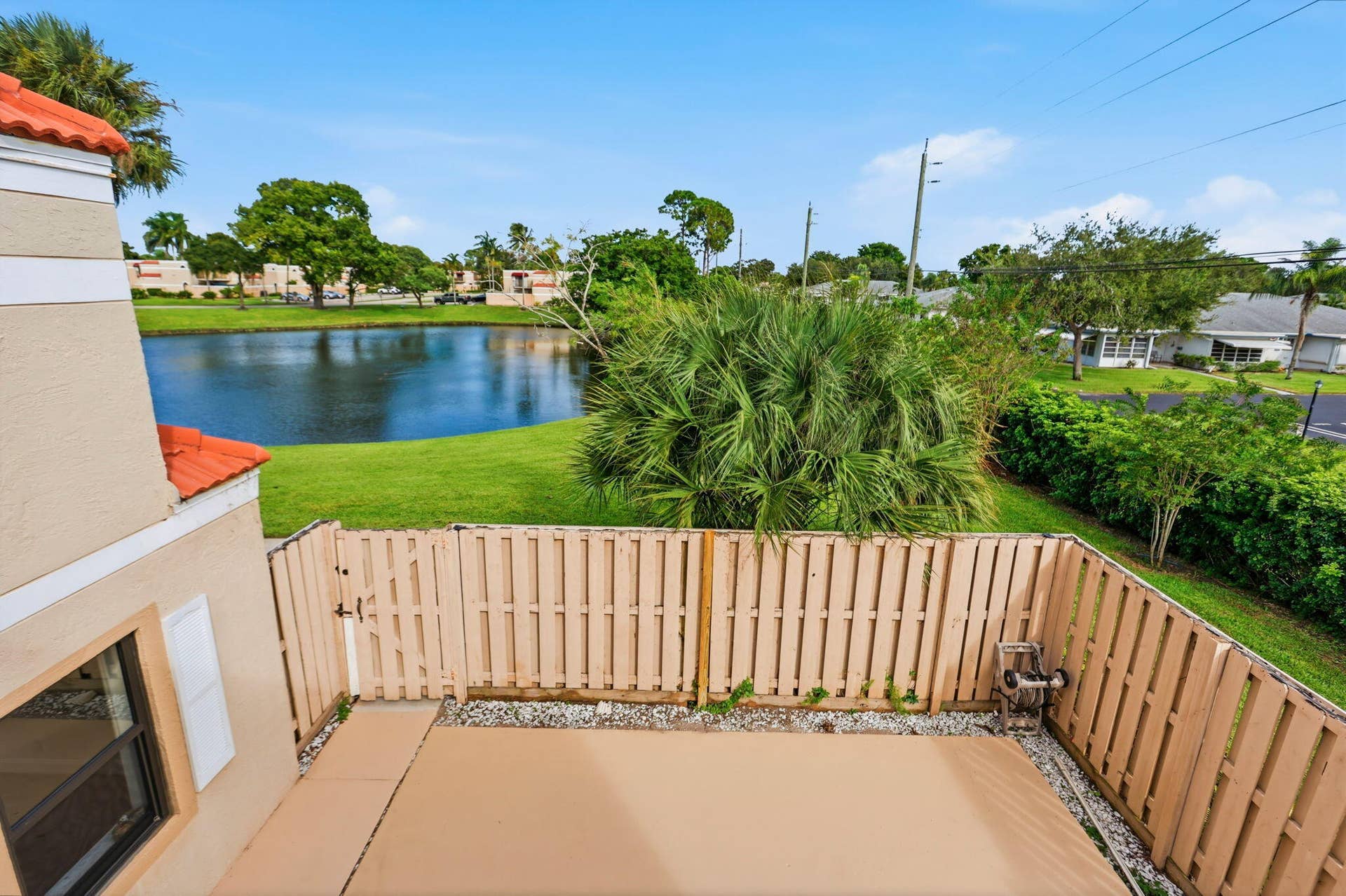 Private fenced patio area with a paved surface and gravel borders