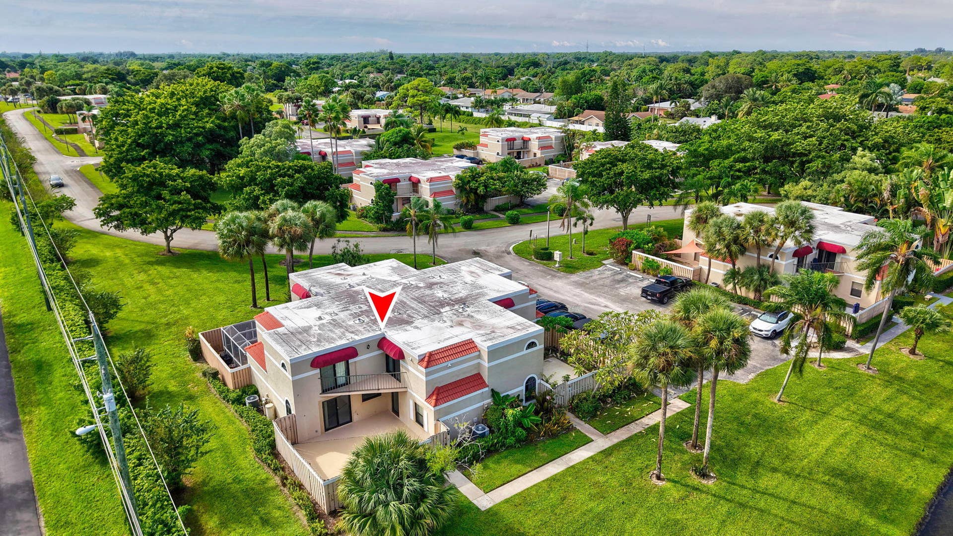 Two-story residence featuring a private patio, upper-level balcony, and exterior awnings