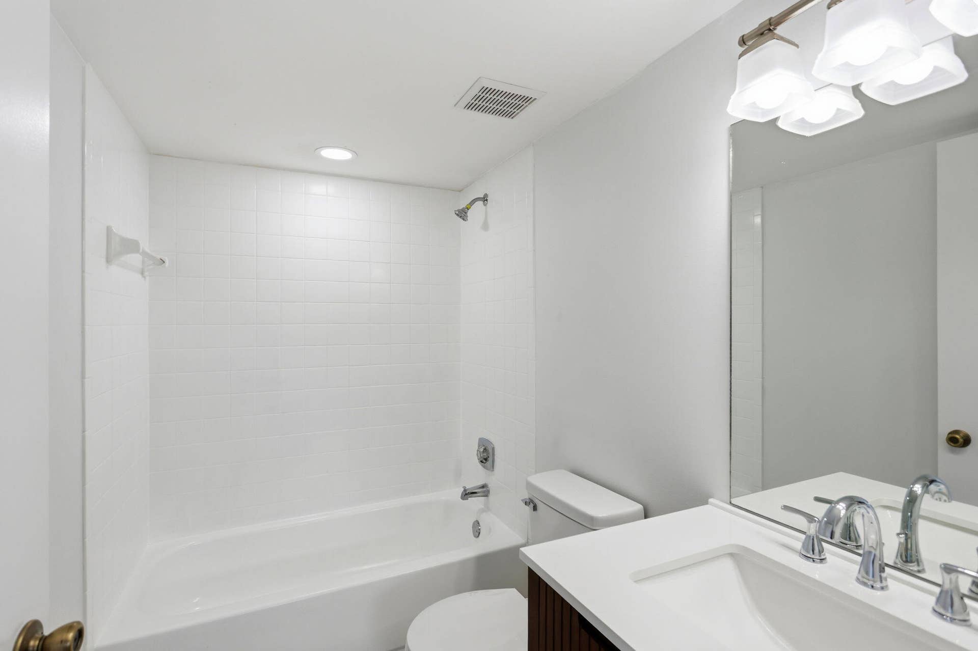 Bathroom with a white tiled shower, integrated bathtub, and a vanity featuring a white countertop and undermount sink