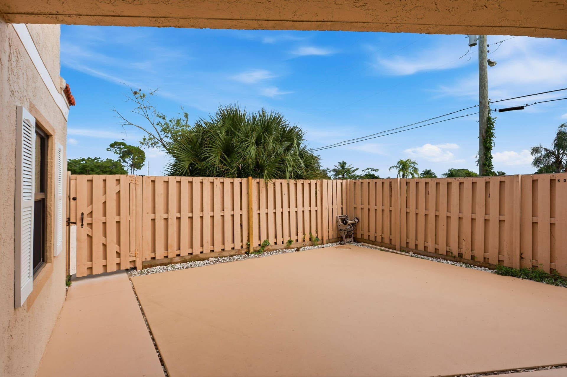 Private paved patio featuring perimeter fencing and a gate