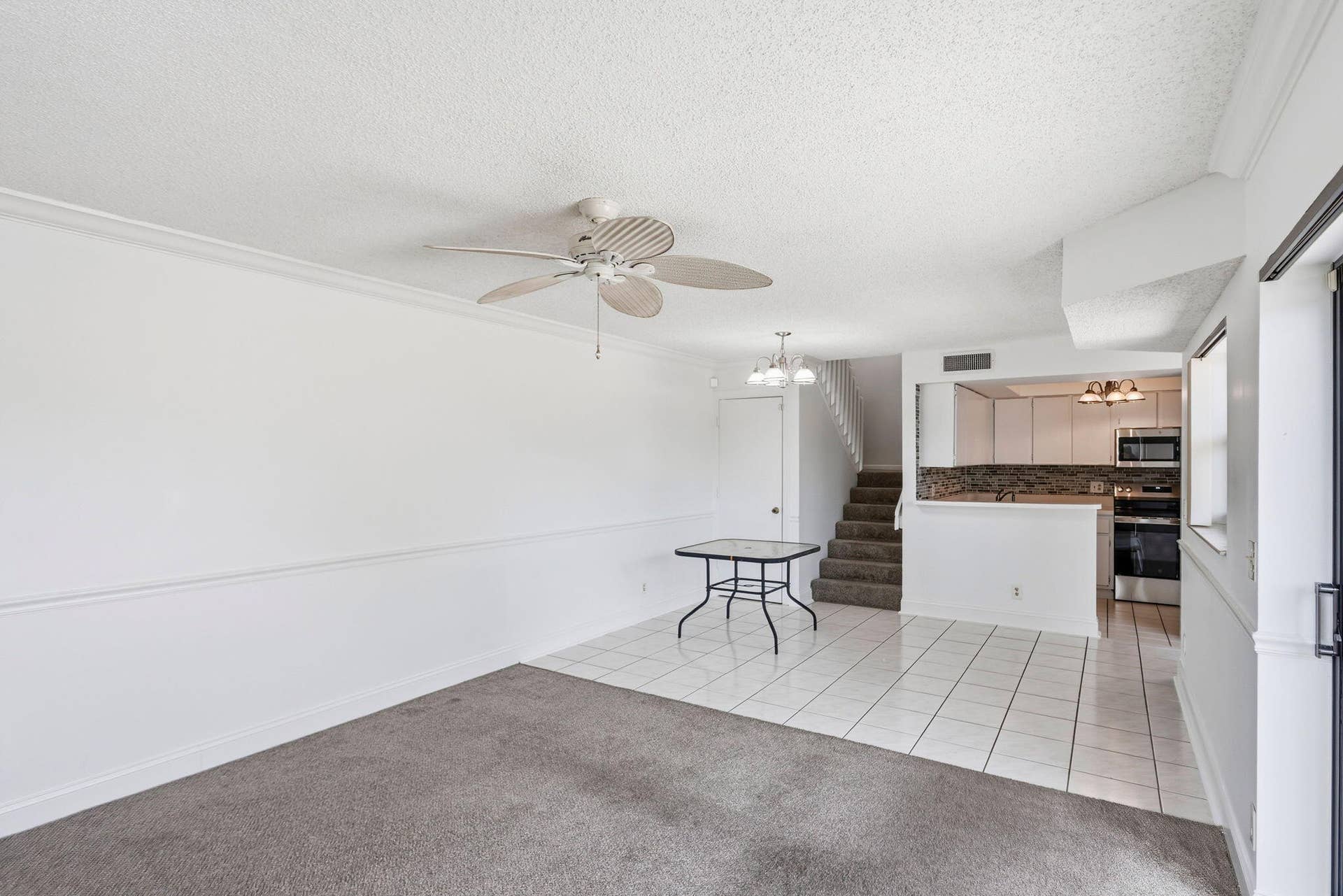 Open-concept living space with partial carpeting and tile flooring