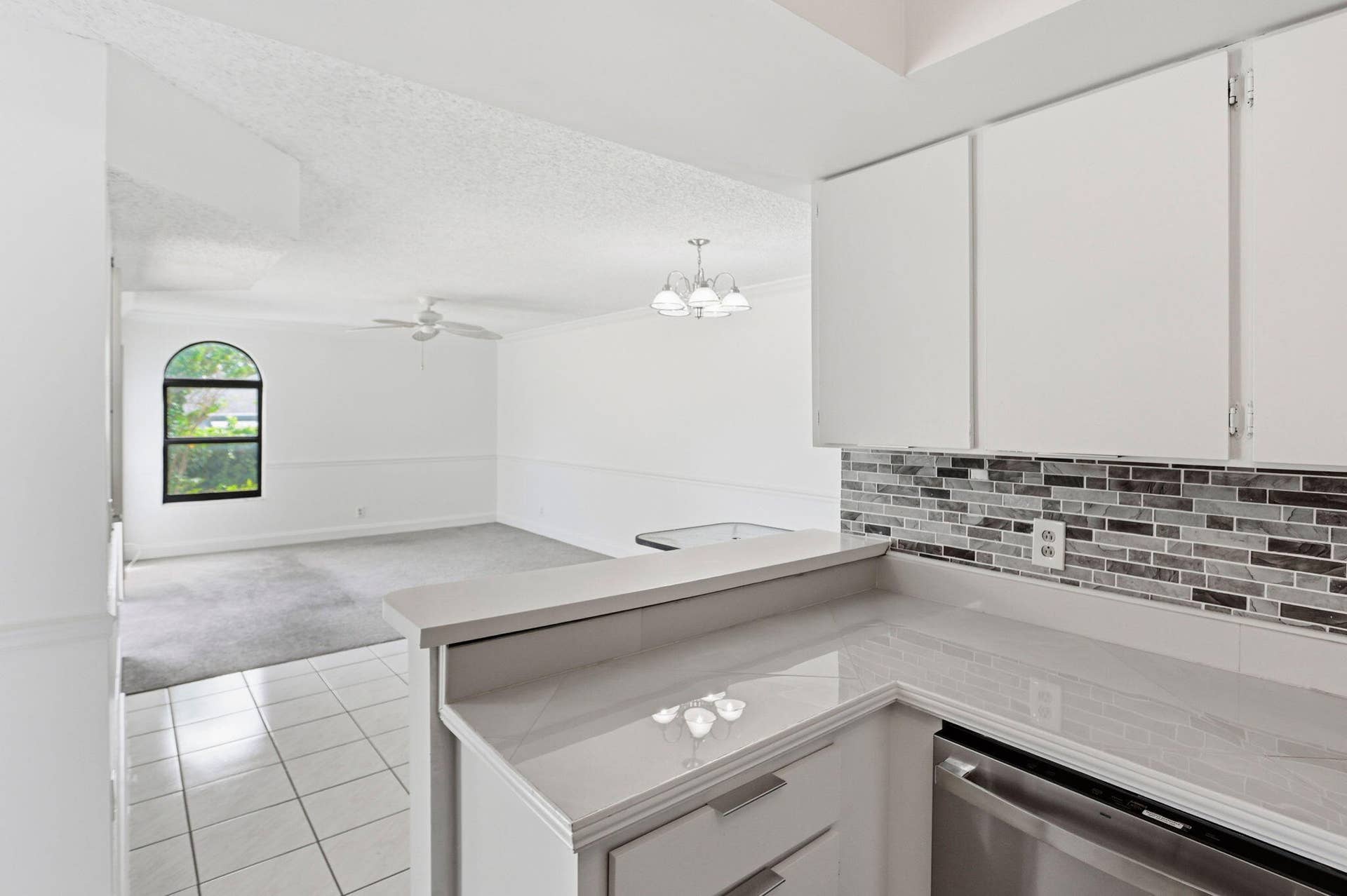 Kitchen featuring white cabinetry, light countertops, and a subway tile backsplash