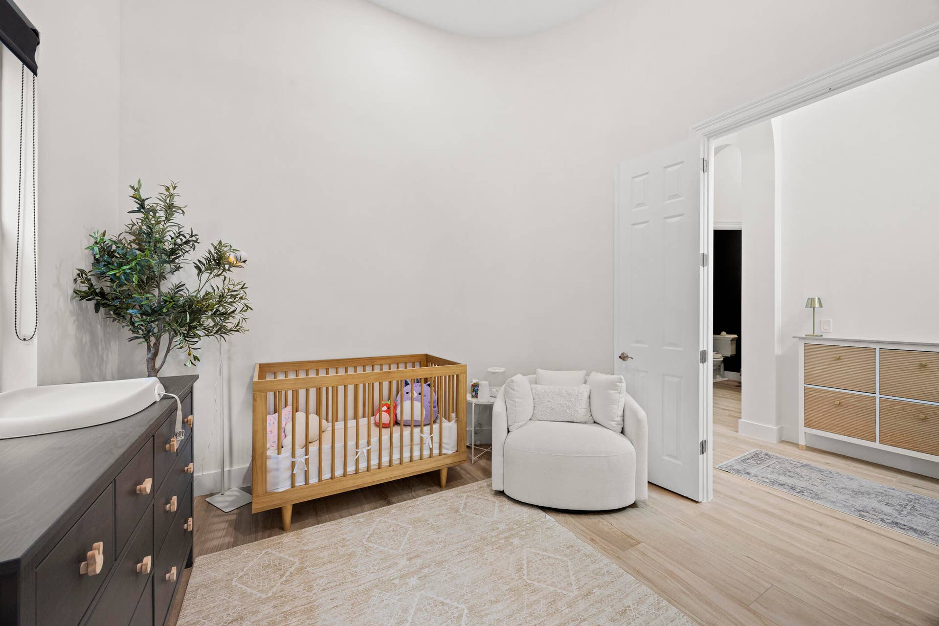 Room featuring high ceilings, wood-finish flooring, and a six-panel door