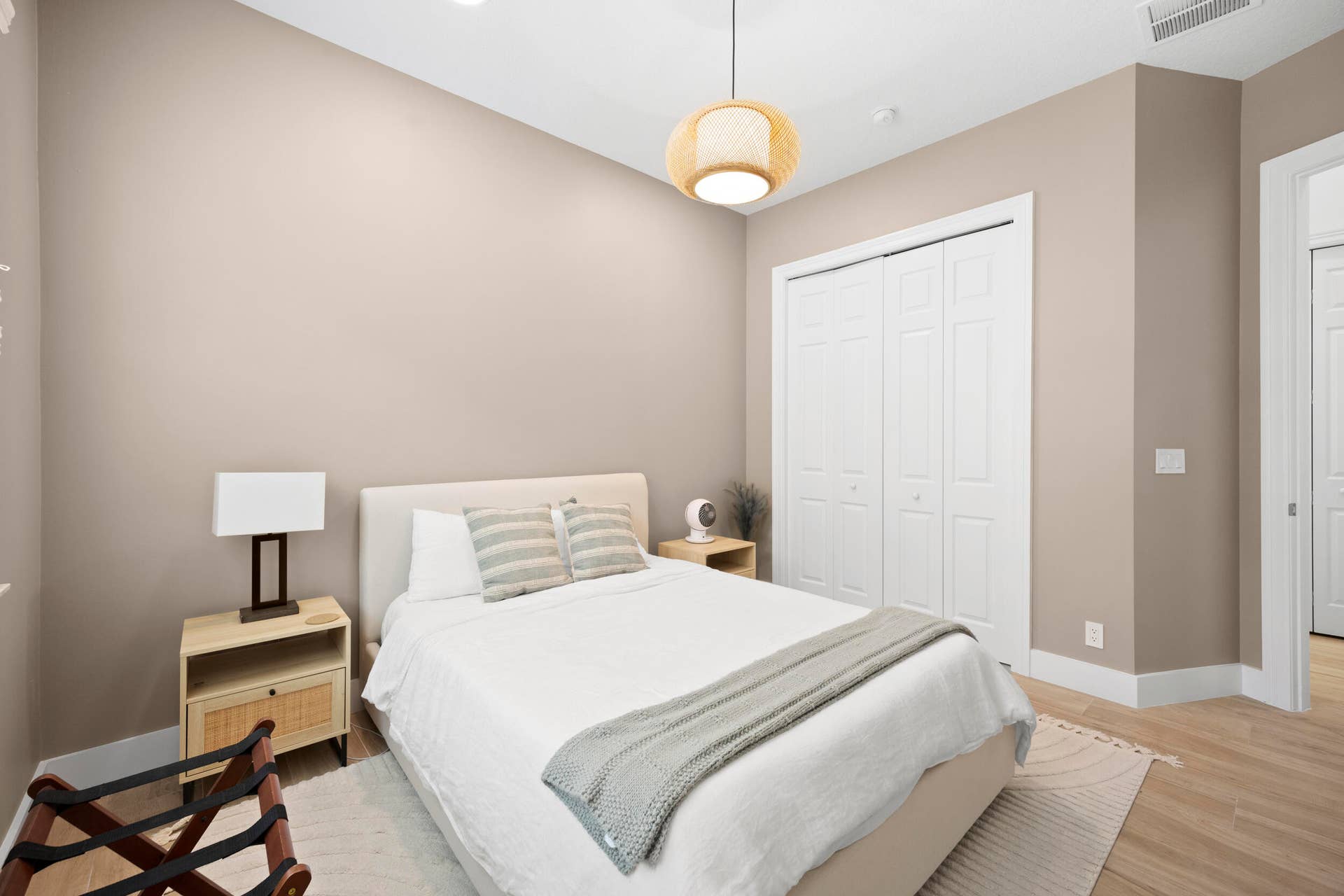 Neutral interior walls, wood-finish flooring, recessed lighting, white panel-style closet doors, and a woven pendant light fixture