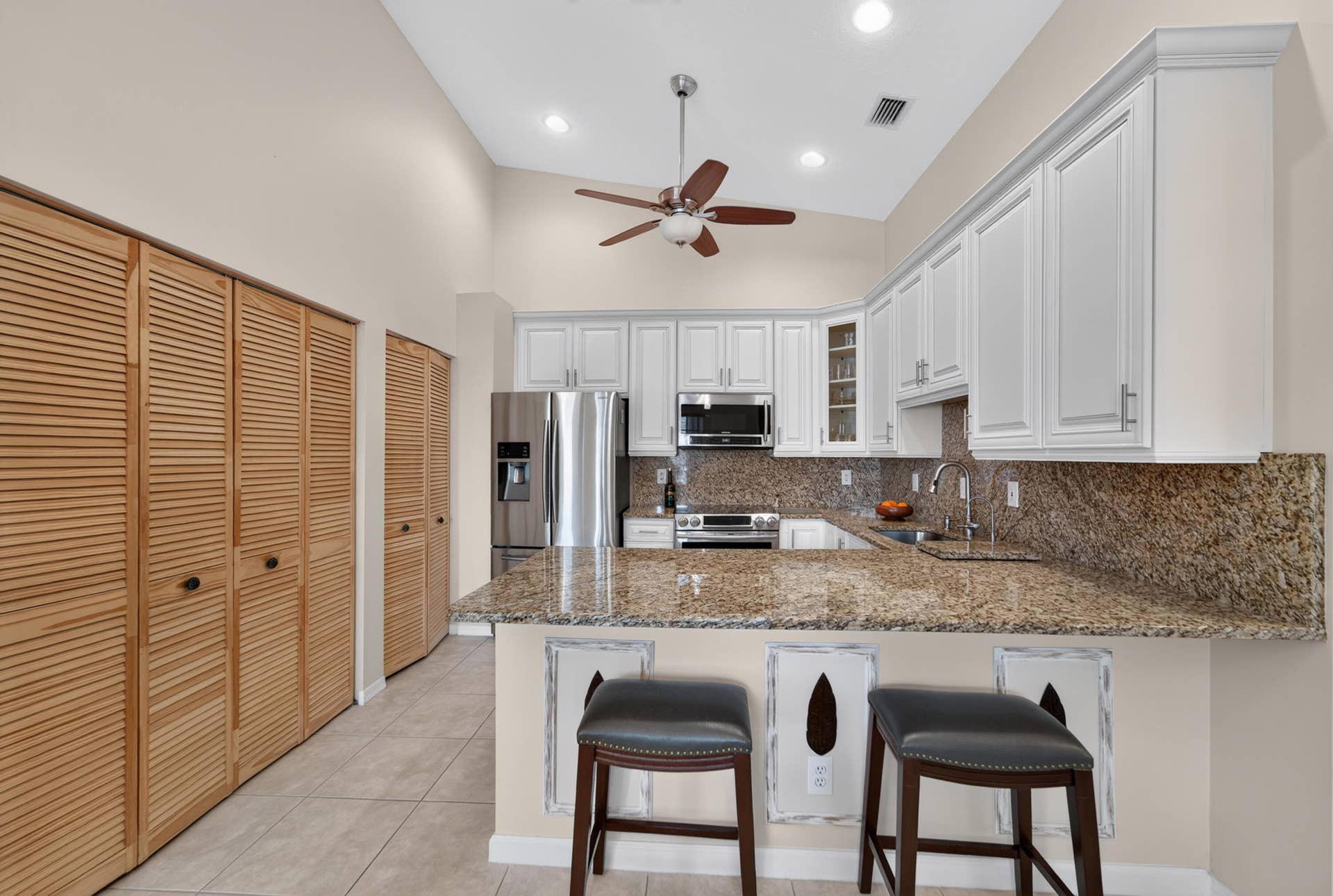 8116 Cormyour Way, Boynton Beach, FL 33472 Large penisula granite island with bar stools, soft close doors, vaulted ceilings, fan, doors to washer in dryer in unit.