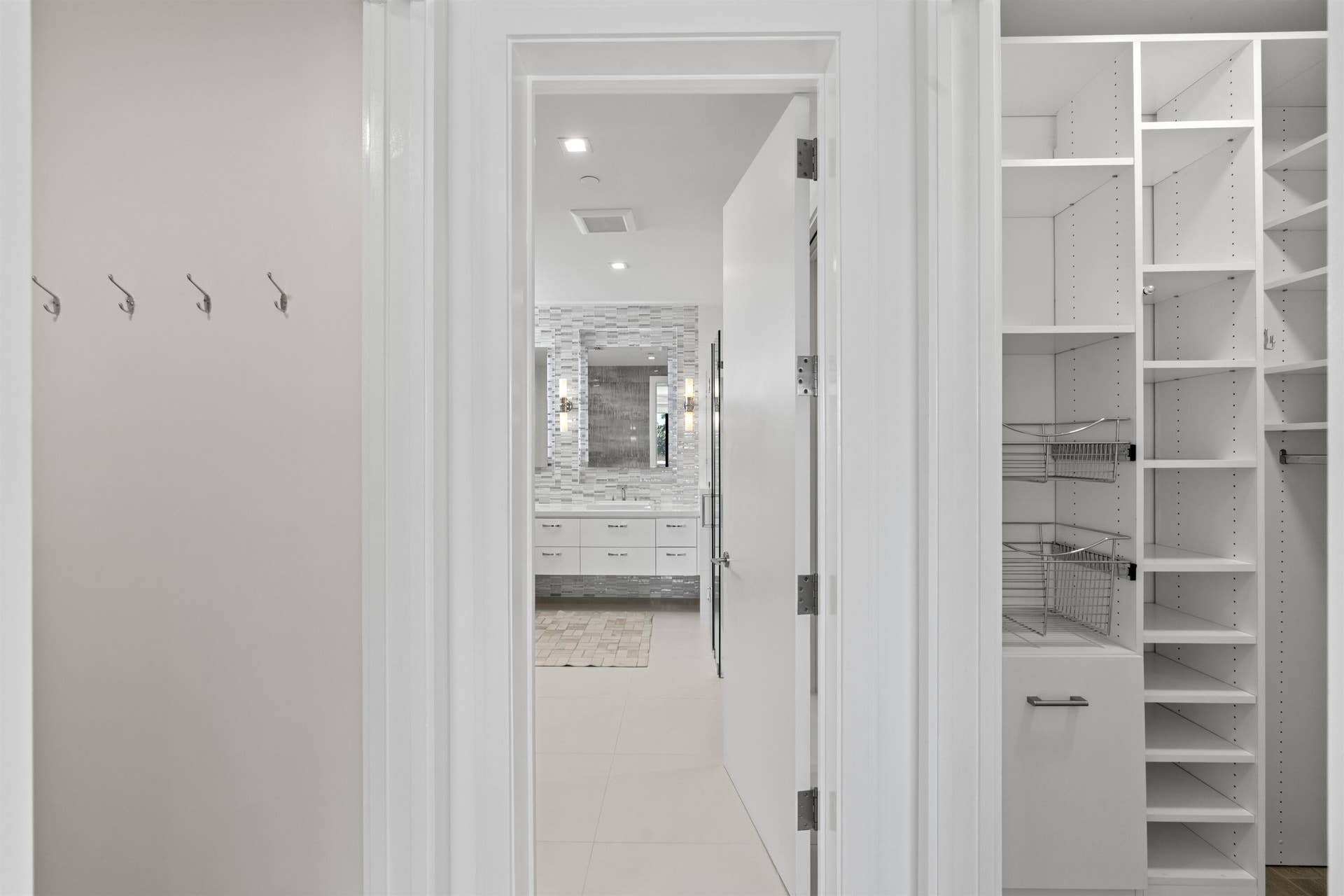 Custom fitted his and hers closets in Primary Suite leading to bathroom