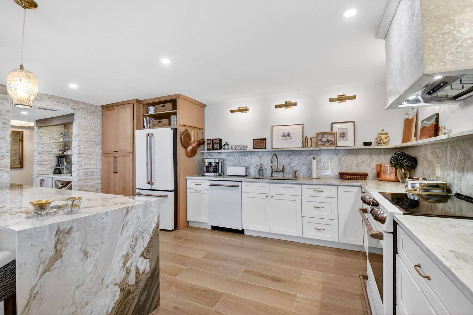 Kitchen featuring stone countertops with waterfall edge, wood-finish flooring, custom cabinetry, tiled backsplash, and recessed lighting
