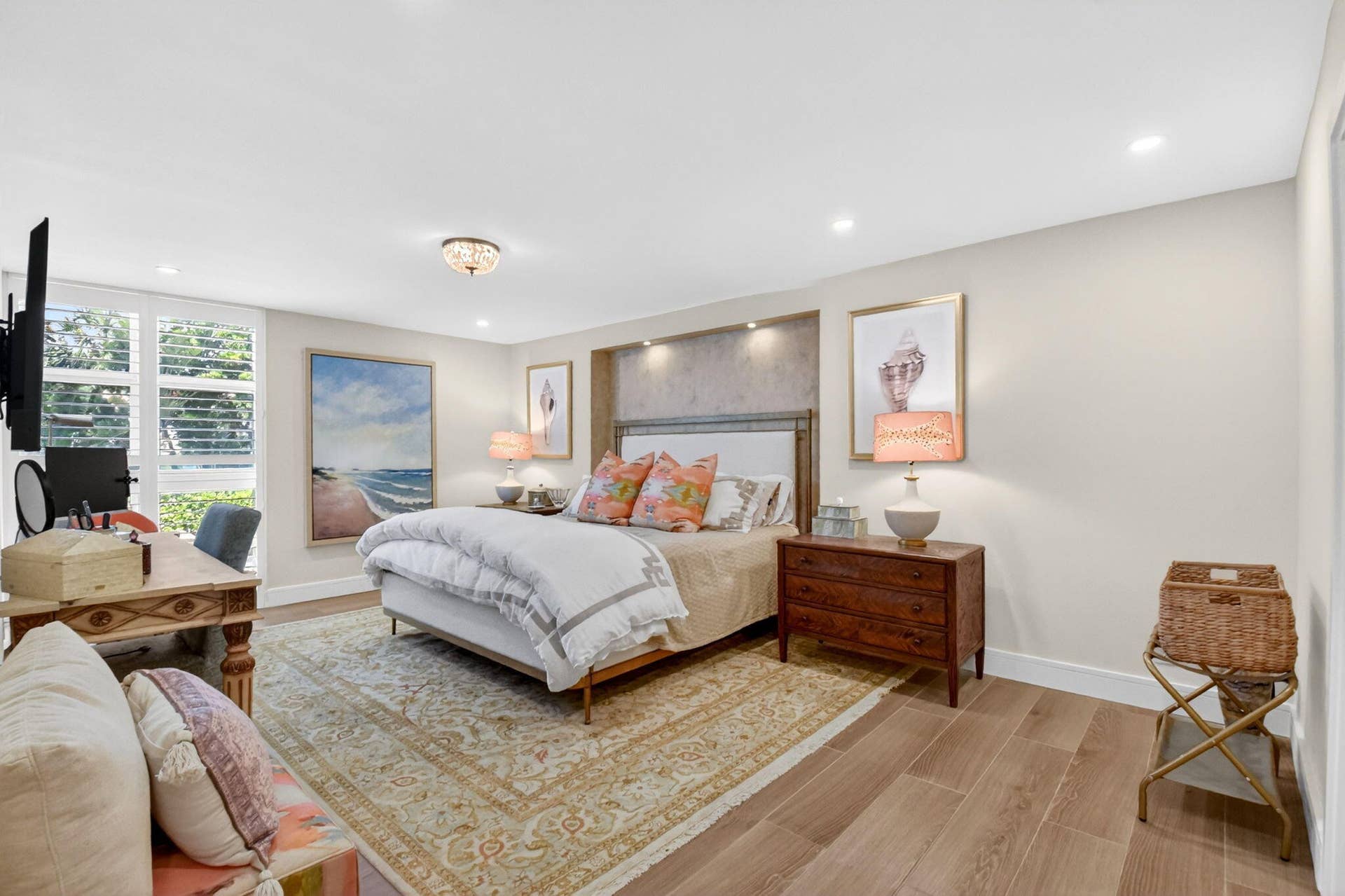 Neutral color palette featuring wood-finish flooring, recessed ceiling lighting, a dedicated recessed wall niche with integrated accent lighting, and multi-pane windows with plantation shutters