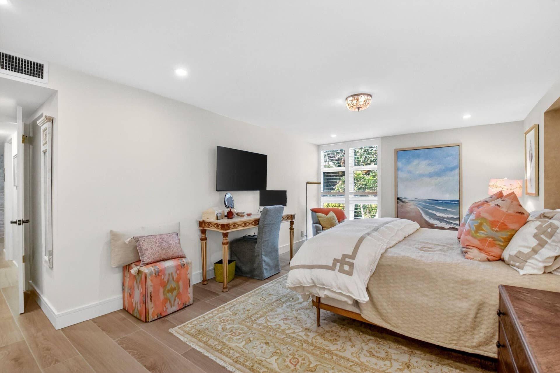Neutral-toned bedroom featuring wood-finish flooring, recessed lighting, and expansive multi-pane windows