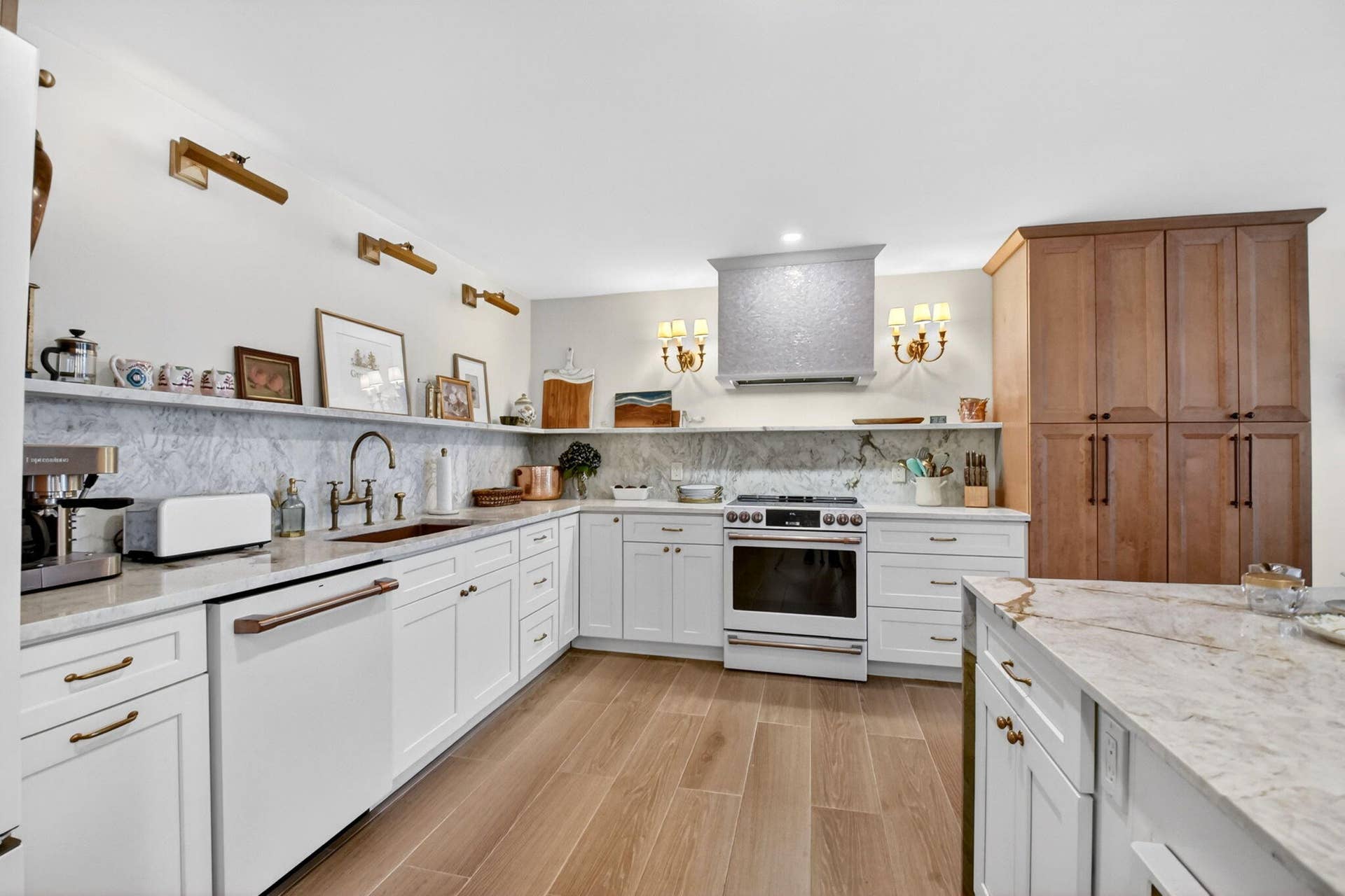 Kitchen featuring white shaker-style cabinetry, a stone-patterned backsplash, wood-finish flooring, a stainless steel range with a decorative hood, and a stone-topped center island