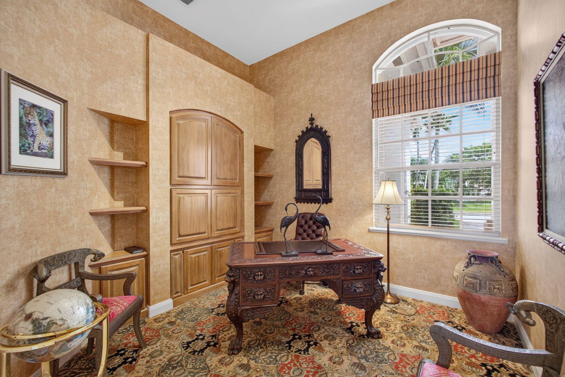 42 Windward Isle, Palm Beach Gardens, FL 33418 Room featuring custom built-in wood cabinetry with integrated shelving and an arched window with a fanlight