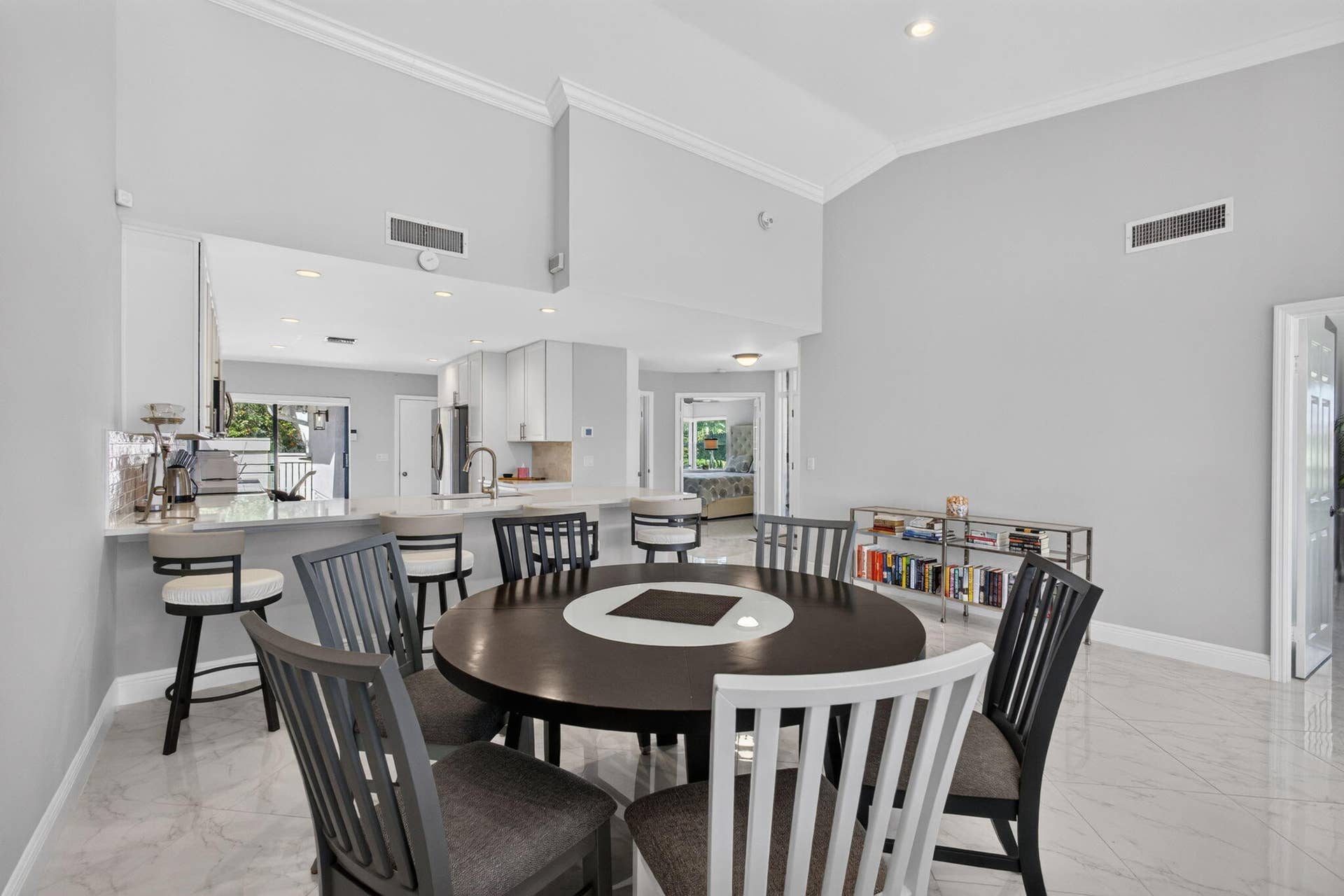 543 Prestwick Circle, Palm Beach Gardens, FL 33418 Open-concept space featuring vaulted ceilings, polished tile flooring, recessed lighting, and a kitchen island with a breakfast bar
