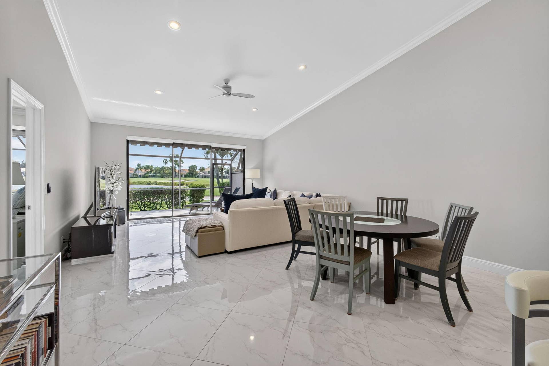 543 Prestwick Circle, Palm Beach Gardens, FL 33418 Open-concept living space featuring high vaulted ceilings, large-format polished tile flooring, recessed lighting, and a multi-panel sliding glass door