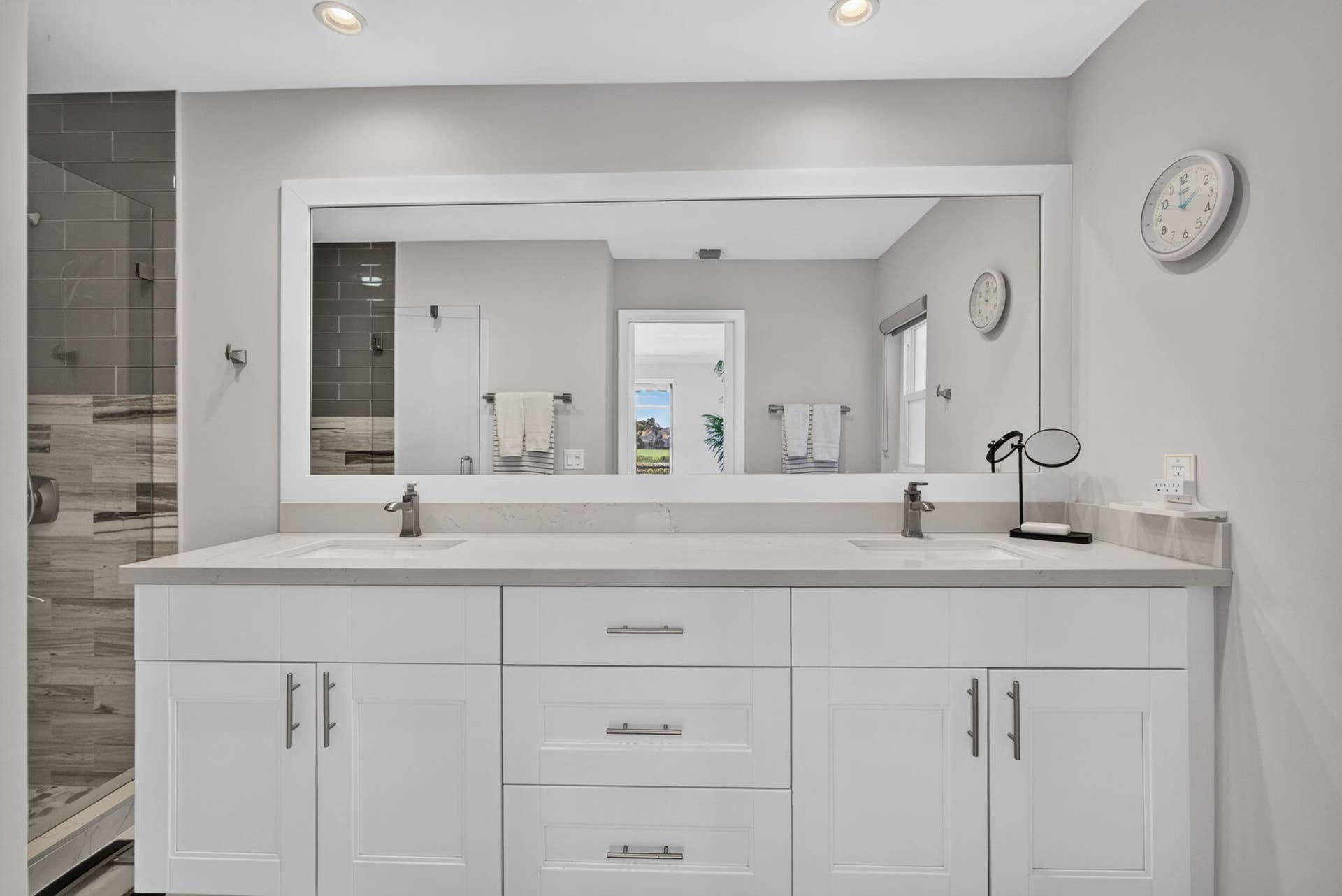543 Prestwick Circle, Palm Beach Gardens, FL 33418 Dual-sink vanity with white shaker-style cabinetry, quartz countertop, polished metal hardware, and a large rectangular mirror