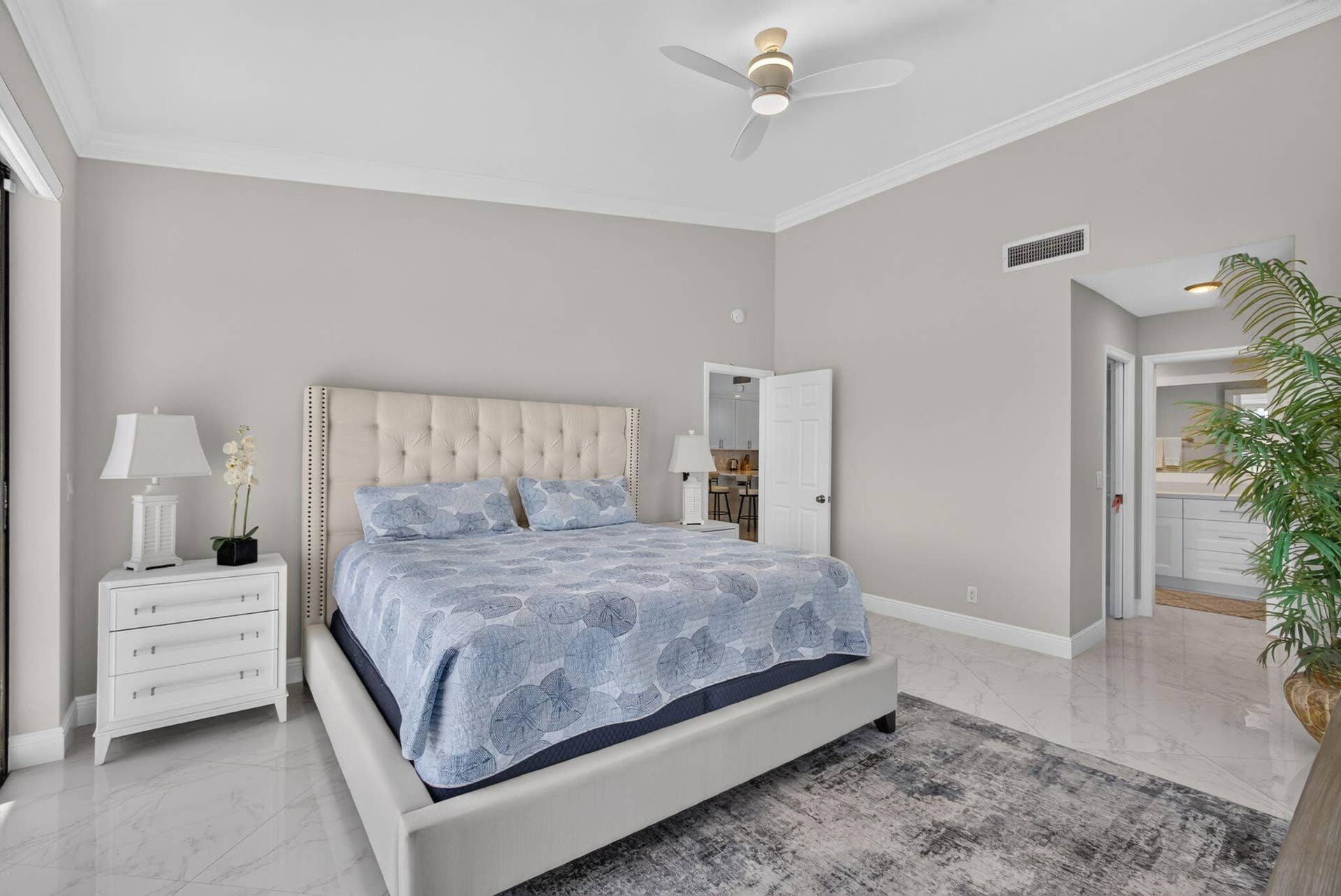 543 Prestwick Circle, Palm Beach Gardens, FL 33418 Neutral-toned room featuring high ceilings, crown molding, a modern ceiling fan, and large-format polished tile flooring
