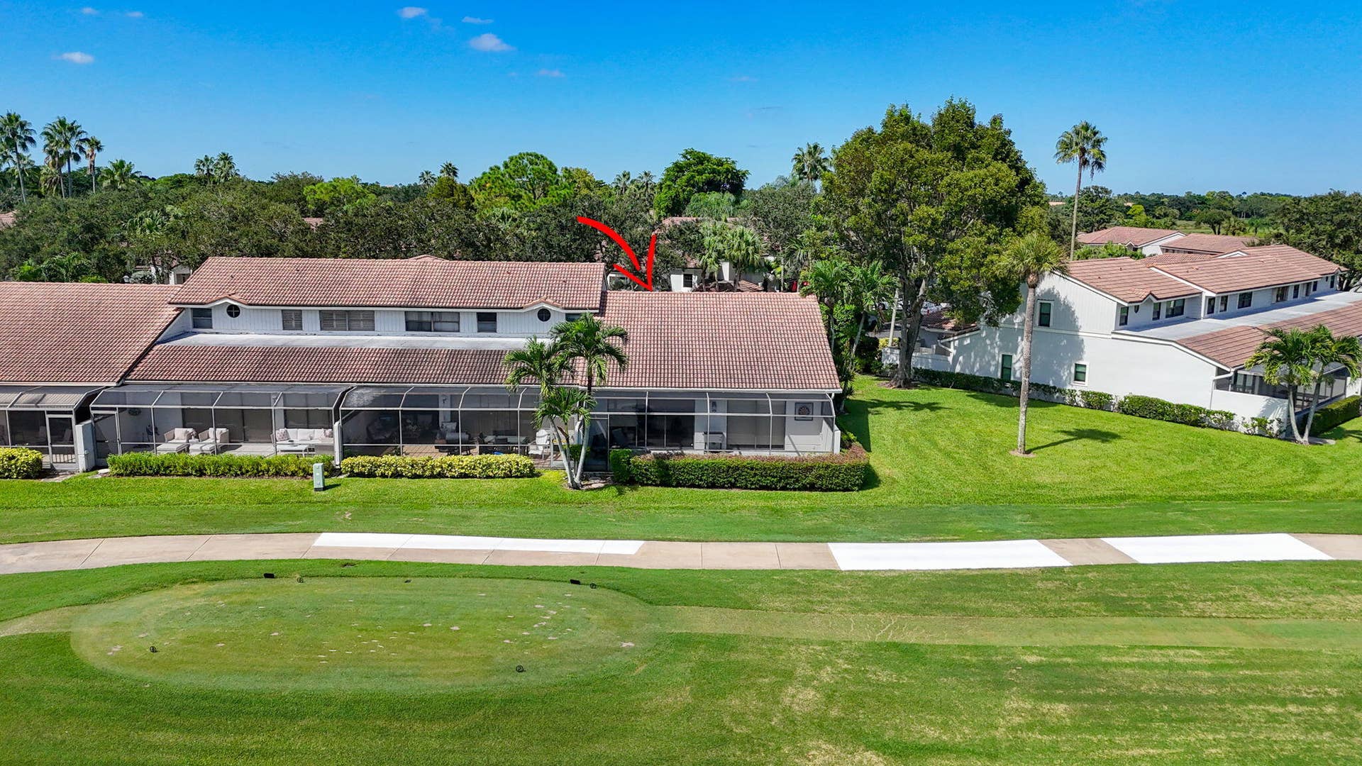 543 Prestwick Circle, Palm Beach Gardens, FL 33418 Aerial perspective of multi-unit residential property featuring a shingle roof, screened-in rear enclosures, manicured lawn, and proximity to golf course grounds