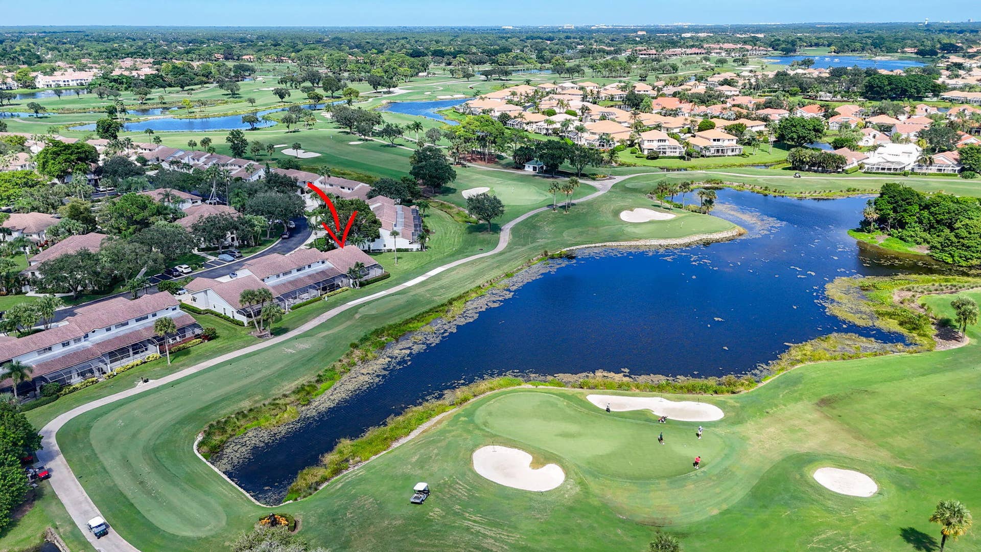543 Prestwick Circle, Palm Beach Gardens, FL 33418 Aerial perspective featuring multi-story residential building, golf course fairway, sand bunkers, and waterfront acreage