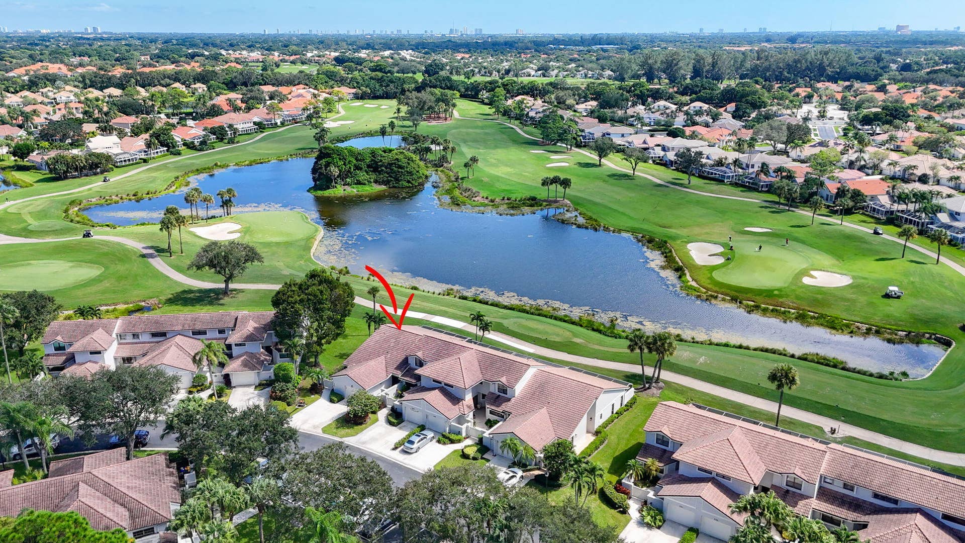 543 Prestwick Circle, Palm Beach Gardens, FL 33418 Aerial perspective featuring a multi-unit property with tile roofing, situated along a golf course fairway with direct water access