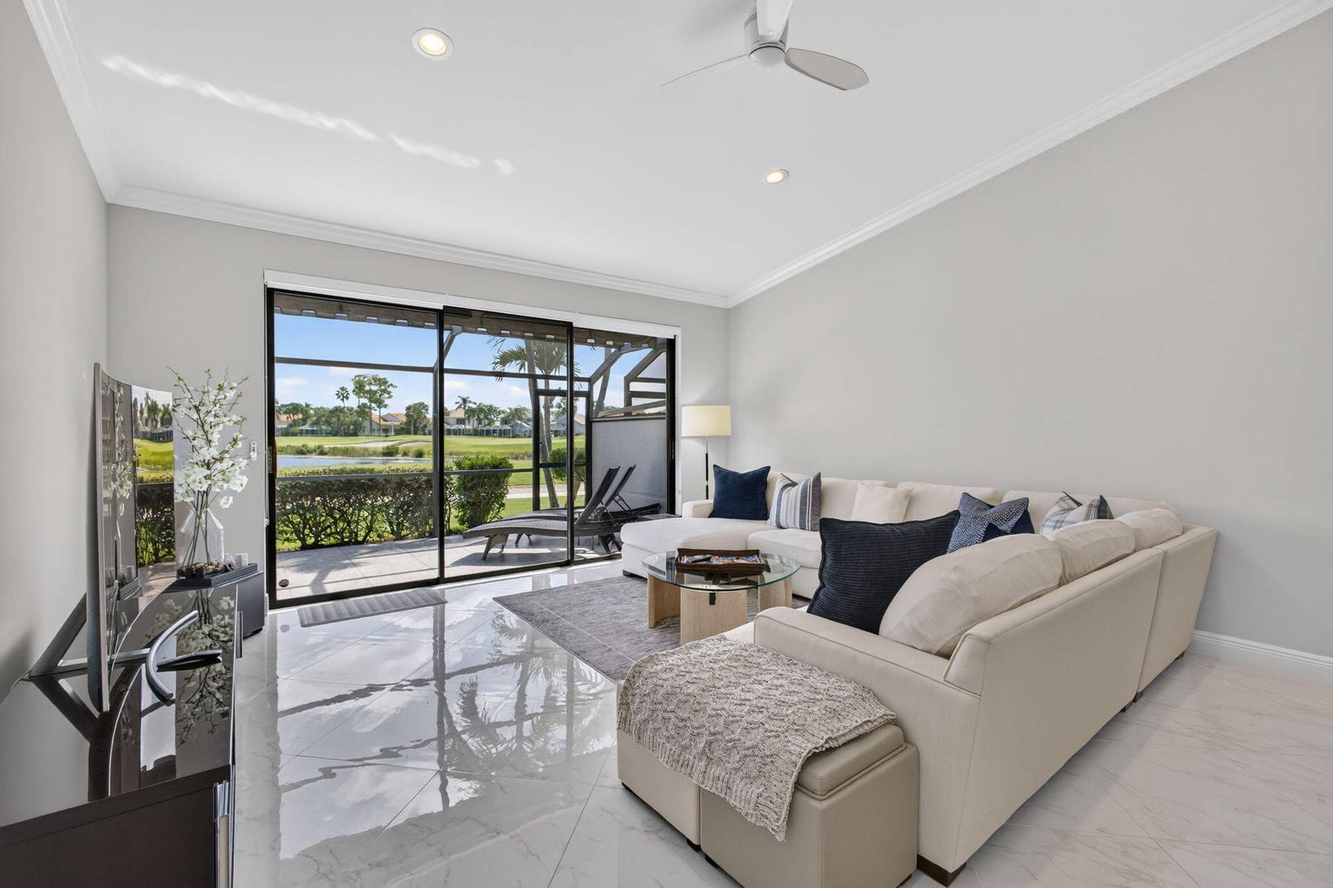 543 Prestwick Circle, Palm Beach Gardens, FL 33418 Large format tile flooring, recessed lighting, ceiling fan, and expansive sliding glass doors opening to a screened patio