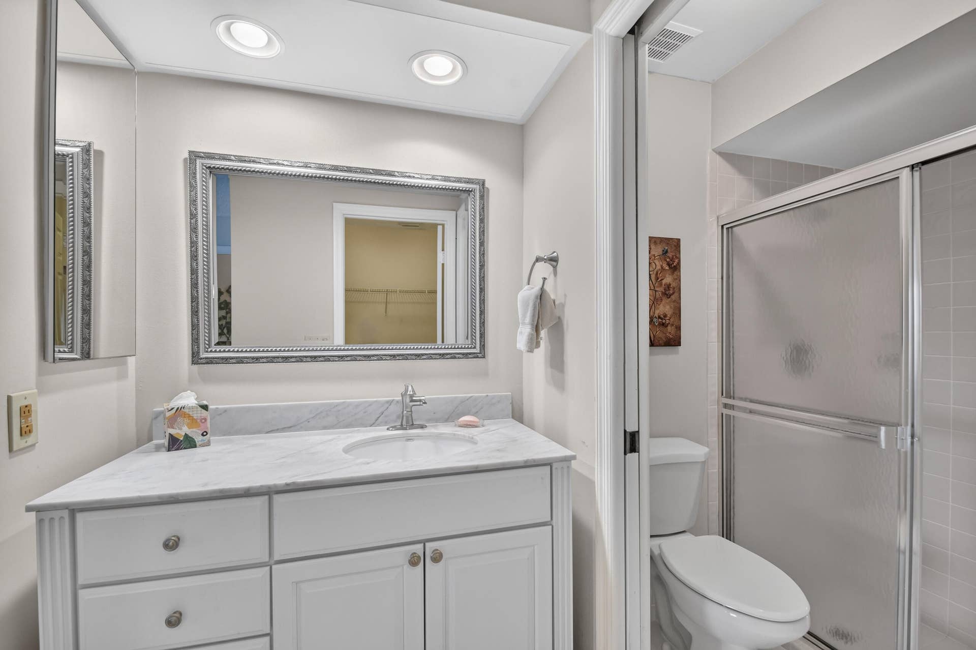 Bathroom featuring a white vanity cabinet with stone countertop, undermount sink, recessed ceiling lighting, and a walk-in shower with glass enclosure